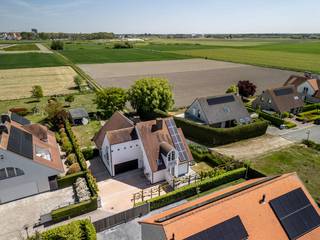 In een van de meest gegeerde en rustige residentiële wijken van Knokke-Heist bevindt zich deze recente villa, een uitzonderlijke woning waar comfort, energiezuinigheid en ligging samenkomen. Met een panoramisch uitzicht over de uitgestrekte polders biedt deze villa een unieke combinatie van rust en openheid, terwijl u toch vlakbij het strand, winkels en het openbaar vervoer bent.De villa is gebouwd op een royaal perceel van 1.362 m² en beschikt over alle hedendaagse technieken die bijdragen aan een duurzaam en zorgeloos wooncomfort. Zonnepanelen, laadpaal en een warmtepomp zorgen voor een energie-efficiënte levensstijl, zonder in te boeten op luxe. Binnenin geniet u van 361 m² bewoonbare oppervlakte, verdeeld over drie volwaardige slaapkamers, een ruime en lichtrijke badkamer, en een ingebouwde sauna die zorgt voor een vleugje wellness in eigen huis.De woning beschikt verder over een ruime inpandige garage én extra parkeermogelijkheden op de oprit, ideaal voor bezoekers of gezinnen met meerdere wagens.Dit is een zeldzame opportuniteit voor wie op zoek is naar een instapklare villa met een adembenemend uitzicht.Indeling:GLV:- inkomhall met gastentoilet- bureau- living- eetplaats- open keuken met eetplaats en zicht op tuin- bijkeuken- ruime garage1steV:- masterbedroom met dressing- 2 volwaardige slaapkamers- nachthall met toilet- badkamer bestaande uit dubbele wastafel, ligbad, douche en saunaUniek vastgoed te koop in Knokke-Heist!*Deze AI-visualisaties zijn bedoeld als inspiratie. Er werd geen rekening gehouden met technische specificaties, stedenbouwkundige voorschriften of de concrete mogelijkheden tot realisatie.