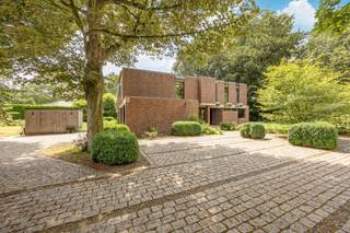 <p><strong>"Villa Olmenrode", modernistische villa (Arch. Paul Meekels, bouwjaar 1972) op een perceel van 1965 m²<br /><br /><em><u>Indeling</u></em></strong>: inkomhal, zithoek, speel/tv kamer, eetkamer, keuken, bijkeuken, garage, berging, atelier, 2 overdekte terrassen, 2 dakterrassen, 4 slaapkamers, dressing, twee badkamers, wasplaats/doucheruimte, bureau (slaapkamer 5), lounge/werkhoek, tuinberging</p>
<p>​Welkom bij <strong>Villa Olmenrode</strong>, een in het groen verscholen modernistische villa van de hand van architect Paul Meekels (bouwjaar 1972) gelegen op een zuidgericht perceel van 1965 m² nabij het centrum van Vosselaar en Turnhout. Openbaar vervoer, sportclub, bossen en scholen liggen allen op wandelafstand.</p>
<p>De afgelopen jaren is deze villa grondig en met veel smaak vernieuwd, waarbij esthetiek, modern wooncomfort en duurzame materialen naadloos samenkomen.</p>
<p>Benedenverdieping met inkomhal en gastentoilet. De woonkamer, keuken en tv-kamer werden de afgelopen jaren vernieuwd door binnenhuisarchitecte Britt Van Namen wat zich heeft vertaald in een doordacht lijnenspel en maatwerk van topkwaliteit. Opvallend zijn de hoge plafonds en de connectie die er is met de 2 bureauruimtes op de bovenverdieping. Let ook op de open vernieuwde trap in beton ciré, een waterdichte, naadloze pleistertechniek met industriële uitstraling. Nieuwe keuken met kastwerk, toestellen en een werkblad ingelegd met corian.<br /><br />Voorts een dubbele inpandige garage met nieuwe automatische poorten. Aansluitend aan de garage bevindt zich een hobby atelier met verzwaarde elektriciteit. Via de open trap bereiken we de bovenverdieping waar ook de overloop met practische bureauruimte werd bevloerd met beton ciré. De ouderslaapkamer is voorzien van fraai ingemaakt kastwerk en make-up tafel en heeft een aansluitende dressing en badkamer met inloopdouche. Het geheel met een erg fraaie en kwalitatieve afwerking. Drie kinderslaapkamers, een bureau en verder een lounge/werkhoek met mooi zicht op de woonkamer. Op de bovenverdieping bevinden zich overigens twee gezellige dakterrassen met een mooi zicht op de tuin.<br /><br />Verwarming met elektrische vloerverwarming en radiatoren. Epc-label E echter zonder renovatieplicht (erfgoed)! Slechts € 450 maandelijkse kosten voor elektriciteit inclusief verwarming, verwarming zwembad en huishoudelijk verbruik. Geen gas!<br /><br />Niet alleen van binnen, maar ook aan de buitenzijde is de woning ingrijpend vernieuwd met het oog op de toekomst:</p>
<strong>​Gevel-en betonrenovatie:</strong> De gevels zijn recent volledig aangepakt. <strong>Nieuwe hardhouten afzelia raampartijen:</strong> De grote, vernieuwde glaspartijen zorgen voor een overvloed aan natuurlijk daglicht<br />
<p>​De tuin biedt volledige privacy en vormt een verlengstuk van het interieur. Tuin, tuinberging, nieuw zwembad met automatisch roldek, toegangspoort en omheining werden volledig vernieuwd. Wat opvalt zijn de grote overdekte terrassen met haardvuur</p>
<p><strong>Troeven</strong></p>
- Residentieel en groen gelegen te Vosselaar met veel privacy<br />- architectenwoning met karakter en bovendien instapklaar<br />- ​<strong>Vernieuwingen:</strong> oa nieuw zwembad, nieuwe maatkeuken, badkamer, kastwerk, vernieuwde gevel en nieuwe raampartijen<br />- Conforme elektriciteit tot 2039<br />- Elektrische vloerverwarming<br />- Geen renovatieplicht (inventaris bouwkundig erfgoed)<br />
<p><strong>​"Villa Olmenrode"</strong>, een unieke kans voor wie zorgeloos wil verhuizen naar een woning met een uitgesproken signatuur en karakter!<br /><br /><strong>Bijzondere informatieplicht:</strong> in aanvraag</p>
<p><span><br /><br /><br /><br /></span><span></span><span></span><span></span></p>