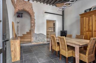 <p>Deze woning uit ca. 1600 ligt nabij het Conscienceplein. Het gebouw werd in 2024 gemoderniseerd met veel respect voor de authentieke elementen. Denk aan: originele houten balken, spiltrap, historische schouwen, smeedijzeren muurankers en de prachtige gevel.<br /><br />Met zes volwaardige slaapkamers, drie tot vier stijlvolle badkamers, een slim verwarmingssysteem en een afgewerkte kelder met wellnessopties, opent deze woning de deur naar tal van mogelijkheden. Van karaktervolle stadswoning tot een unieke vakantiewoning in het hart van Antwerpen.<br /><br /><strong>Indeling:<br /></strong>Bij binnenkomst betreed je de eetkamer op natuursteen, waar de pelletkachel discreet centraal staat. Deze verwarmt via kanalen de volledige woning. Aansluitend vind je de open keuken op keramisch parket, uitgerust met oven, microgolfoven, inductiekookplaat, dampkap, vaatwasser, koelkast, diepvriezer en een Corian werkblad.<br /><br />Via de traphal bereiken we de tv-hoek op originele cementtegels en verder het gastentoilet. De massieve houten spiltrap brengt je naar de eerste verdieping, met twee ruime slaapkamers en een moderne badkamer met douche, toilet en lavabo met meubel.<br /><br />Op de tweede verdieping zijn er opnieuw twee slaapkamers en een badkamer met ligbad, toilet en lavabo met meubel.<br /><br />Nog een verdieping hoger tref je twee kamers met zicht op de Boerentoren en Consciencebibliotheek, een derde badkamer en een buitenkoer met trap naar het dak.<br /><br /><strong>Buitenruimtes:<br /></strong>Buitenkoer op de eerste en derde verdieping, bereikbaar via de hal. Vanaf de koer op de derde verdieping is er een trap naar het dak voor uitbreiding met dakterras eventueel. Van hieruit heeft u de mooiste zichten over Antwerpen.</p>
<p><strong>Bijzonderheden:<br /></strong>Gemoderniseerd in 2024.<br />Pelletkachel met kanalisatie.<br />Zes slaapkamers & 4 badkamers.<br />Authentieke elementen.<br />Polyvalente ruimte in kelder.<br />Perfect voor vakantieverhuur.<br /><br /><strong>Ligging:<br /></strong>Gelegen in het historische centrum van Antwerpen, vlak bij het levendige Conscienceplein, met directe toegang tot cultuur, horeca, winkels en openbaar vervoer.</p>