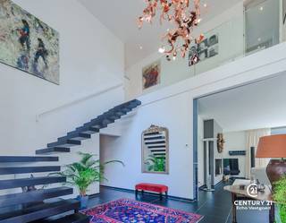 <h3>Exclusieve architectenvilla op toplocatie in villawijk De Lint</h3>
<p>Op een prachtig zuidwestgericht perceel, op wandelafstand van het unieke natuurgebied De Liereman, bevindt zich deze hedendaagse en onder architectuur gebouwde villa. Deze uitzonderlijke woning combineert tijdloze architectuur, royale leefruimtes en een hoogwaardig afwerkingsniveau met een uitstekende bereikbaarheid. Zowel Eindhoven als Antwerpen bevinden zich op slechts ca. 25 minuten rijden, waardoor u geniet van het beste van twee werelden: rust, natuur en een vlotte verbinding.</p>
<p>Bij aankomst wordt u verwelkomd in een ruime inkomhal met vestiaire en gastentoilet. Via stijlvolle dubbele deuren betreedt u de indrukwekkende woonkamer, waar de grote raampartijen een panoramisch zicht bieden op de prachtig aangelegde tuin. Het overvloedige natuurlijke licht en de fraaie tuinzichten creëren een unieke woonbeleving. Aansluitend bevindt zich een open ruimte die perfect dienst kan doen als bureau of leeshoek, open van karakter maar toch afzonderlijk van de leefruimte.</p>
<p>De sfeervolle doorkijkhaard vormt een elegante verbinding tussen de woonkamer en de royale leefkeuken. Deze keuken verkeert in perfecte staat van onderhoud, is uitgerust met kwalitatieve toestellen, beschikt over een groot werkblad en biedt plaats aan een ruime eettafel. Dankzij de grote schuiframen loopt binnen naadloos over in buiten. Achter de keuken bevinden zich een praktische bijkeuken en een aparte wasruimte. De inpandige dubbele garage met automatische poort en personenlift vervolledigt het comfort op het gelijkvloers.</p>
<p>Op de verdieping geeft de royale nachthal toegang tot de indrukwekkende master suite met inloopdressing en een luxueuze badkamer. Daarnaast zijn er nog twee volwaardige slaapkamers met een gedeelde badkamer. De ruime studiekamer kan eenvoudig worden ingericht als vierde slaapkamer en beschikt bovendien over een eigen terras.</p>
<p>Ook buiten weet deze villa te imponeren. De volgroeide, volledig omheinde tuin biedt optimale privacy en vormt een waar groen paradijs. Meerdere zonneterrassen en een overdekt terras nodigen uit om in alle seizoenen van het buitenleven te genieten. Het extra losstaande garagegebouw biedt bijkomende mogelijkheden voor wagenliefhebbers, hobbyruimte of extra opslag.</p>
<p>Naast het uitzonderlijke wooncomfort onderscheidt deze villa zich door haar onderhoudsvriendelijke karakter. Dankzij de duurzame aluminium raamprofielen en de kwalitatieve gevels in gevelsteen zijn er geen schilderwerken aan het buitenschrijnwerk of de buitenmuren nodig, wat resulteert in een stijlvolle uitstraling met een minimum aan onderhoud.<br /><br /><strong>Een uitzonderlijke villa voor wie ruimte, comfort, privacy, kwaliteit en een onderhoudsarme woonomgeving weet te waarderen.</strong></p>
<h3>Troeven van deze woning</h3>
<ul>
<li>Wandelafstand van natuurgebied De Liereman</li>
<li>Zuidwestgericht perceel met optimale bezonning</li>
<li>Personenlift naar de verdieping</li>
<li>Vloerverwarming op gelijkvloers én verdieping</li>
<li>Inpandige dubbele garage met automatische poort</li>
<li>Extra losstaand garagegebouw met bergzolder</li>
<li>Alarmsysteem</li>
<li>Zonnescreens</li>
<li>Fraai aangelegde, volledig omheinde tuin</li>
<li>Grote terrassen en overdekt, verwarmd terras</li>
</ul>
