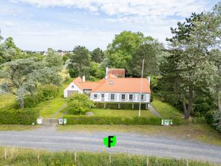 Exceptioneel vastgoed in hartje Koksijde/St.-Idesbald.<br /><br />Midden in de duinen en omgeven door een exclusief en residentieel karakter vinden we deze karaktervolle vissersvilla. Gelegen op een magnifiek stuk grond van maar liefst 1560m2 in natuurgebied ‘Noordduinen’. Deze parel is rustig doch zeer centraal gelegen, op fietsafstand van winkels, restaurants, zee/strand… en met een uiterst vlotte verbinding (op 6km) van de E40. De combinatie van duinen en de natuur zorgen voor een bijzondere unieke toets.<br /><br />De villa beschikt over een geïnstalleerde keuken (MIELE-toestellen) met rode grestegels en afgewerkt met 17e Eeuwes Delftse tegels, een lichtrijke ruime leefruimte met open haard bestaande uit rode/zwarte grestegels en talrijke kwalitatieve elementen en materialen o.a. 18e Eeuwes Delftse tegels, 17e Eeuwes Spaanse deuren in massief hout, muurverlichting in smeedijzer… <br /><br />Vervolgens zijn er 4 volwaardige slaapkamers, 2 badkamers (ligbad, wasmeubel, toilet) en een grote garage met aansluiting wasmachine/droogkast.<br /><br />In de weelderige tuin bevindt zich een groot bijgebouw (30m2) die men kan omvormen tot bar/mancave…, een tuinhuis (5m2) én een buitentoilet. De terrassen zijn in blauwe arduin en terracotta tegels met verschillende geïntegreerde elementen in smeedijzer.<br /><br />De woning is gelegen in zonevreemd gebied. Natuurgebieden Noordduinen. <br /><br />TROEVEN WONING:<br /><br /><ul><li>dak volledig vernieuwd in 2019<br /><br /></li><li>nieuw septisch systeem in 2020 conform de wet IBA<br /><br /></li><li>buitenverlichting vernieuwd<br /><br /></li><li>beglazing + ramen vernieuwd in 2012<br /><br /></li><li>originele waterput en vlaggenmast aanwezig<br /><br />Laat u charmeren door dit buitengewoon eigendom en leg uw bezoek vast.</li></ul>