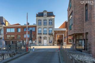 This well-located office is situated in the heart of Mechelen on the Dijle, behind the attractive façade of an elegant heritage building, overlooking the river, the Kraanbrug and the iconic wooden houses that adorn many Mechelen travel guides.<br /><br />It consists of an inspiring meeting room (28m²) at the front of the building, bathed in light, with authentic mouldings and beautiful windows, and an office space (36m²) with kitchen, cloakroom and guest toilet at the rear of the building. The two spaces are separated by a stately entrance hall, which provides access to the apartments above, but can also be used as an entrance to the office, accessible via the gate on the side façade.<br /><br />It is a quiet and pleasant place to work and hold meetings for up to 8 employees, and the high ceilings give an extra feeling of space. <br />Underground parking spaces can be rented nearby if required.<br /><br />Practical information:<br />- monthly rent: €1,450<br />- monthly service charge: €100<br />- annual property tax: +/- €1,450<br />- available from +/- October 2026 and no later than 1/02/2027<br />- 3 months rent deposit<br /><br />Would you like to come and see this office for yourself? Please contact Tinne on 0477 60 21 99 or tinne.schotsmans@quares-trevi.be. <br />See you soon!