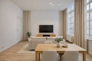 <p>Wonen in het historische hart van Antwerpen, achter een statige gevel met karakter? Dit knappe gelijkvloerse appartement combineert charme, comfort en een absolute topligging.</p>
<p>Via de zijingang betreedt u het appartement en komt u binnen in een praktische inkomhal waar maatwerk werd voorzien voor een vestiaire. De woon- en leefruimte bevindt zich vooraan en geniet dankzij de hoge plafonds en grote raampartijen van een prachtige lichtinval en een bijzonder ruimtelijk gevoel.</p>
<p>De open keuken sluit naadloos aan op de leefruimte en is volledig uitgerust met een keramische kookplaat, koelkast met vriesvak, oven en vaatwasser — ideaal voor wie houdt van comfortabel en zorgeloos wonen.</p>
<p>Achteraan bevinden zich twee volwaardige slaapkamers (ca. 13 m² en 12 m²). De grootste slaapkamer beschikt over maatwerk en beide kamers geven rechtstreeks toegang tot het aangename terras van ca. 20 m² — een heerlijke buitenruimte midden in de stad.</p>
<p>De moderne badkamer biedt alle comfort met zowel een douche als ligbad en een dubbele wastafel met meubel. Daarnaast is er een privatief gastentoilet aanwezig.</p>
<p>Extra praktisch zijn de aparte berging met aansluiting voor wasmachine en droogkast én de privatieve kelderruimte.</p>
<p>Een instapklaar en veelzijdig appartement dat perfect kan dienen als eigen woonst, stijlvolle pied-à-terre of slimme investering — en dit op een AAA-locatie waar alles op wandelafstand ligt.</p>