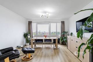 <p><span>Dit appartement is ideaal gelegen net buiten de Singel, op een steenworp van het Rivierenhof — perfect voor wie rustig wil wonen met de stad binnen handbereik. Dankzij de vlotte verbindingen met het openbaar vervoer, de wagen en het velo-deelsysteem geniet je hier van een uitstekende bereikbaarheid. Ook winkels en supermarkten bevinden zich in de directe omgeving.</span></p><p><span>Het appartement bevindt zich op de zesde verdieping van een goed onderhouden gebouw met vijftien verdiepingen. Het dak werd reeds geïsoleerd en de zijgevel werd recent vernieuwd. De vaste kosten bedragen circa €400/maand. In 2021 werd het appartement volledig gerenoveerd, waardoor je hier zonder zorgen kan intrekken. De elektriciteit is conform en de aluminium ramen zijn voorzien van dubbele beglazing.</span></p><p><span>Je komt binnen in de hal met twee praktische ingemaakte vestiairekasten. Vooraan bevindt zich de lichtrijke woonkamer (32 m²), waar je elke dag kan genieten van een prachtig uitzicht over de Antwerpse skyline en indrukwekkende zonsondergangen.</span></p><p><span>De aparte keuken (8 m²) is voorzien van een basisuitrusting. De twee slaapkamers van 10 m² en 16 m² bevinden zich aan de oostzijde, waardoor je hier ontwaakt met de ochtendzon en een open zicht. De grootste slaapkamer geeft bovendien toegang tot het terras van 5 m² met oost-oriëntatie.</span></p><p><span>Centraal in het appartement bevindt zich de badkamer (5 m²) met ligbad/douche en lavabo, en er is ook een apart toilet aanwezig. Tot slot beschikt het appartement nog over een privatieve kelderberging.</span></p><p><span>Ben je op zoek naar een instapklaar appartement met veel lichtinval en unieke vergezichten op elk moment van de dag? Mis deze kans niet! Bewoonbare opp. 93 m² – ref.: bruto vloeropp. Voor meer info of een gratis schatting surf naar </span><span><span>www.hansimmo.be</span></span></p><p><span> </span></p>