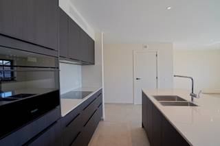 Op wandelafstand van het centrum van Buggenhout vindt u dit instapklare, compleet geschilderd, nieuwbouwappartement dat uitblinkt in comfort en energiezuinigheid. Dankzij de nieuwste technieken zoals vloerverwarming en een warmtepomp geniet u van zeer lage energiekosten.<br />Het appartement is door zijn ligging zeer lichtrijk en beschikt over twee slaapkamers, een ruime en lichtrijke woonkamer met open keuken en stijlvol keukeneiland, een aparte berging, een afzonderlijk toilet en een badkamer uitgerust met een ruime inloopdouche en ingebouwd ligbad. Het zuid-gericht terras biedt de perfecte plek om in alle rust van de zon te genieten. Alle ruimtes zijn voorzien van verlichting en zullen ook nog voorzien worden van gordijnen waardoor het appartement dus compleet instapklaar is. Bovendien is in de huurprijs een ondergrondse parkeerplaats inbegrepen, wat dit appartement nog praktischer maakt.<br />Huurprijs: 1.200 EUR + 100 EUR gemeenschappelijke kosten<br />Referentie: 5637