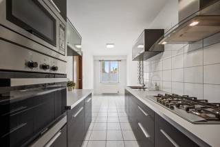 Dit ruime appartement in Tienen biedt een comfortabele en praktische woonruimte met een bewoonbare oppervlakte van 101 m². Het gebouw, daterend uit 1988, heeft een degelijke constructie en een tijdloze uitstraling die zorgt voor een aangename leefomgeving. Het appartement beschikt over drie slaapkamers, ideaal voor gezinnen of als extra werk- of hobbyruimte. Daarnaast is er één badkamer aanwezig die van alle basisvoorzieningen is voorzien. Voor het parkeren zijn er maar liefst twee garageplaatsen inbegrepen, wat een groot gemak biedt in een drukke omgeving. Dankzij de gunstige ligging in Tienen geniet u van een goede toegang tot lokale voorzieningen, scholen en openbaar vervoer. Dit maakt het appartement een uitstekende keuze voor wie op zoek is naar een comfortabele en praktische woning met voldoende parkeermogelijkheden.