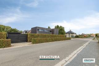 In de bijzonder aangename en landelijke woonwijk te Landbeek in Mollem bevindt zich deze uitstekend onderhouden open bebouwing, gelegen in een rustige, doodlopende straat. De woning werd gebouwd in 2002 en vanaf 2016 kwalitatief gerenoveerd, met bijzondere aandacht voor afwerking, comfort en hedendaagse technieken.De bijzonder lichtrijke leefruimte geniet dankzij de grote raampartijen van een mooie verbinding met het zuidwestelijk georiënteerde terras en de tuin. De vernieuwde vloer, stijlvolle ingemaakte kasten en prachtige keuken van Broothaerts zorgen voor een warm en harmonieus geheel. Ook de aluminium ramen werden vernieuwd.De woning beschikt over een praktische indeling met drie slaapkamers, waarvan één met aansluitende dressing en een afzonderlijke bureau- of hobbyruimte. Verder zijn er twee toiletten en een inpandige garage aanwezig.Ook technisch is de woning uitstekend uitgerust met centrale verwarming, zonnepanelen, een thuisbatterij, domotica en een alarmsysteem.De eigendom bevindt zich op een perceel van 6a 77ca, heeft een gevelbreedte van maar liefst 14,40 meter en biedt ruime parkeergelegenheid op eigen terrein.Een bijzonder verzorgde en instapklare gezinswoning waar rust, ruimte en hedendaags wooncomfort samenkomen!Meer info of een bezoek ter plaatse? Contacteer Structura op 02/460.80.46 of via info@structura.be.