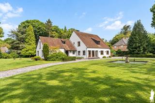 <strong>Verrassend ruime villa op prachtig perceel van ca. 4.175 m²</strong><br /><br /><strong>Via de dubbele, statige oprijlaan bereikt u deze ruime en degelijk gebouwde villa, gelegen in een uiterst rustige villawijk op een prachtig breed perceel van ca. 4.175 m². De groene omkadering en royale voortuin zorgen meteen bij het binnenrijden voor een bijzonder aangename eerste indruk en een gevoel van rust en privacy. Binnen verrast de woning met royale leefruimtes, veel lichtinval en een uitzonderlijk veelzijdige indeling. Ideaal voor een groot gezin, wonen en werken onder één dak of comfortabel wonen op het gelijkvloers.</strong><br /><br /><strong>Gelijkvloerse verdieping</strong><br />- een ruime <strong>inkomhal </strong>met gastentoilet en handenwasser<br />- een afzonderlijke kamer, geschikt als<strong> bureau, praktijk- of extra slaapkamer</strong><br />- een ruime <strong>leefruimte </strong>op natuursteen met open haard<br />- een volledig ingerichte <strong>keuken</strong> <br />- een aanpalende berging, ideaal als voorraadkamer<br />- een lichtrijke <strong>tweede</strong> <strong>woonkamer </strong>op parket met grote schuiframen en mooi contact met de tuin<br />- een achterliggend <strong>bureau/polyvalente ruimte </strong>met <strong>badkamer</strong> voorzien van lavabo, toilet en jacuzzi, alsook aansluitende <strong>dressing</strong> waardoor dit gedeelte ideaal is voor wonen op het gelijkvloers.<br />- een bijkomende <strong>polyvalente</strong> kamer, geschikt als speelkamer, tv-kamer, bureau of praktijkruimte<br />- een praktische <strong>wasplaats </strong>met aansluiting voor wasmachine en droogkast<br />- een inpandige <strong>garage</strong> met elektrische poort en spoelbak <br /><br /><strong>Eerste verdieping:</strong><br />- een centrale nachthal met afzonderlijk toilet<br />- <strong>vijf slaapkamers</strong><br />- een <strong>douchekamer </strong>met lavabo<br />- een <strong>tweede badkamer </strong>met dubbele lavabo, toilet en ligbad, met connectie aan de hoofdslaapkamer en nachthal<br />- een ruime <strong>zolderberging</strong> bereikbaar via vlizotrap<br /><br /><strong>Tuin en buitenruimte</strong><br />- een prachtig aangelegde tuin<br />- achtertuin met <strong>veel zon</strong>, veel <strong>privacy</strong> en zicht op <strong>groen</strong><br />- een verzorgd <strong>terras</strong>, volledig opnieuw aangelegd in 2024<br />- twee <strong>tuinbergingen</strong> als extra bergruimte<br />- <strong>oprijlaan met camerabeveiliging en dubbele poorten.</strong><br /><br /><strong>Bijzonderheden</strong><br />- een verrassend <strong>ruime </strong>en <strong>veelzijdige </strong>woning<br />- tal van <strong>mogelijkheden</strong> voor een groot gezin,<strong> kangoeroewonen</strong>,<strong> praktijk of kantoor aan huis </strong>en<strong> wonen op het gelijkvloers</strong><br />- zeer <strong>degelijke</strong> <strong>constructie </strong>en <strong>goed onderhouden</strong><br />- recente <strong>buitenschilderwerken</strong> in 2024<br />- verwarming op <strong>aardgas </strong>d.m.v. radiatoren<br />- <strong>videofonie</strong> en <strong>alarmsysteem</strong><br /><br /><strong>Een solide en bijzonder ruime villa op een uitzonderlijk perceel, met alle mogelijkheden om wonen, werken en ontspannen harmonieus te combineren.</strong>