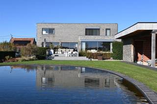 <p><span>Via de inkomhal, met een ruime berging en gastentoilet, betreedt u de leefruimte. Deze bestaat uit een open en lichtrijke living/zithoek met gashaard, een eetgedeelte en een volledig ingerichte open leefkeuken. De keuken is uitgerust met een kookeiland, dubbele lavabo, oven en stoomoven, twee warmhoudlades, een teppanyaki-plaat en een wijnfrigo, alle toestellen van Miele.</span></p><p><span> </span></p><p><span>Op de eerste verdieping bevindt zich de masterbedroom met ensuite badkamer, voorzien van een dubbele inloopdouche, dubbele wastafel en een aparte dressing met inbouwkasten. Daarnaast zijn er nog twee slaapkamers, elk uitgerust met ingebouwde kasten, een apart toilet en een badkamer met ligbad en inloopdouche.</span></p><p><span> </span></p><p><span>De woning is volledig onderkelderd en voorzien van een aparte wasplaats, een grote polyvalente ruimte, een aparte wijnkelder en een dubbele inpandige garage. </span></p><p><span> </span></p><p><span>Er werd gebruikgemaakt van hoogwaardige materialen zoals (moeras)eik, (cappuccino)marmer en natuursteen. Alles is ontworpen met aandacht voor comfort, wat resulteert in een hedendaagse en ruime villa met grote raampartijen die zorgen voor een overvloed aan licht en prachtige zichten op de tuin.</span></p><p><span> </span></p><p><span>Vanuit de volledige woning geniet u van een weids uitzicht op de zuidgerichte tuin en de achterliggende velden. De tuin is volledig omheind en voorzien van een zwemvijver. Verder zijn er een tuinberging en een poolhouse met westgericht overdekt terras, uitgerust met douche- en toiletvoorziening.</span></p><p><span> </span></p><p><span>Extra’s: hoge plafonds, vloerverwarming, gashaard, overal zonnewering (elektrische in living en master), dimlichten, alarm, aparte gekoelde wijnkelder, aluminium ramen, parlofoon, automatische poort, regenwaterput van 10.000 liter, zwemvijver, …</span></p><p><span> </span></p><p><span> </span></p><p><span> </span></p><p><span> </span></p>