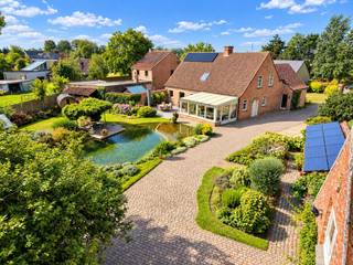 In een rustige en landelijke omgeving te Beke, Lievegem, vinden we deze ruime en instapklare woning op een bijzonder perceel van maar liefst 3.599 m². Een dergelijke oppervlakte in woongebied is vandaag bijzonder schaars.<br /><br />De oorspronkelijke hoeve werd in 1984 verbouwd en doorheen de jaren verder uitgebreid tot een comfortabele gezinswoning. De woning beschikt over aangename leefruimtes, een volledig uitgeruste keuken en een gezellige leefveranda met prachtig zicht op de tuin. Op het gelijkvloers bevindt zich bovendien een aparte bureauruimte.<br /><br />Boven zijn er vier slaapkamers, waaronder een ruime masterbedroom met dressing en buitenterras. Verder zijn er een badkamer, een extra doucheruimte beneden en een praktische opbergzolder.<br /><br />De absolute troef is het ruime en prachtig aangelegde perceel. De volwassen tuin biedt volop privacy en achteraan bevindt zich een bosrijk gedeelte. Centraal in het geheel ligt een schitterende zwemvijver, aangevuld met een vrijstaande sauna en buitendouche – een heerlijke plek om in alle rust te genieten.<br /><br />Ook op technisch vlak is de woning goed uitgerust met dubbele beglazing, rolluiken, centrale verwarming op aardgas, een zonneboiler, zonnepanelen en de nodige isolatie. De woning behaalt een EPC-label B met een score van 124 kWh/m²/jaar.<br /><br />Verder beschikt de eigendom over een ruime oprit, extra parkeerplaatsen, een dubbele garage met elektrische poort en verdieping en twee regenwaterputten.<br /><br />Een ruime, instapklare woning met een uitzonderlijk perceel, volop privacy en een unieke buitenbeleving. Een eigendom die rust en ruimte combineert met het comfort van vandaag.<br />Meer info of een bezoek? Bel WIJSvastgoed op 09 395 80 10!