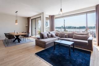 Gelegen op een absolute toplocatie aan de Rijnkaai naast het gekende Red Star Line Museum, geniet dit ruime en lichtrijke appartement van een unieke combinatie van comfort, ruimte en een prachtig frontaal zicht over de Schelde.<br /><br />Via de inkomhal, voorzien van een gastentoilet, komt u terecht in de royale leefruimte. Dankzij de grote raampartijen geniet deze ruimte van een overvloed aan natuurlijk licht en een aangenaam gevoel van openheid. De parketvloer zorgt voor een warme en elegante uitstraling. Aansluitend bevindt zich de moderne open keuken, uitgerust met kwalitatieve inbouwtoestellen en ontworpen als een volwaardig onderdeel van de leefruimte. Vanuit de leefruimte heeft u rechtstreeks toegang tot het terras, waar het frontale Scheldezicht voor een bijzonder aangename woonbeleving zorgt.<br /><br />Verder beschikt het appartement over een praktische berging met aansluitingen voor een wasmachine en droogkast.<br /><br />Aan de rustige achterzijde bevinden zich de drie slaapkamers. De ruime masterbedroom beschikt over rechtstreekse toegang tot een ensuite badkamer, uitgerust met een dubbele lavabo en een ruime inloopdouche. De twee overige kamers zijn flexibel in te richten als slaapkamer, bureau, dressing of hobbyruimte en delen een tweede badkamer met inloopdouche. Alle drie de kamers geven uit op het achterliggende, rustige terras, waardoor ook hier een aangename en serene woonomgeving wordt gecreëerd.<br /><br />Een ondergrondse autostaanplaats is bovendien bij te huren voor € 150 per maand.<br /><br />Huurprijs: 1.895 EUR/maand<br />Beschikbaarheid: onmiddellijk<br /><br />Interesse?<br />Contacteer LISTED voor een bezoek: +32 3 283 51 51.