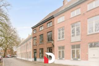 Deze statige burgerwoning is gelegen op een van de meest exclusieve en idyllische pleinen van het historische Brugse stadscentrum, namelijk het Wijngaardplein in het Minnewater. Het eigendom beschikt over een uiterst rationele en praktische indeling.<br />Via een lange inkomhal met hoge plafonds komen we de woonst binnen, verder een 2 ledige leefruimte met zithoek en eetplaats. Deze ruimte is voorzien van een gezellige plankenvloer en 2 authentieke open haarden. <br />Achteraan de woning (met zicht op de koer) vinden we de reeds vernieuwde keuken terug met kookeiland en naastgelegen praktische bijkeuken/berging, een naastgelegen wasplaats en apart gastentoilet.<br /><br />Vanuit de keuken hebben we zicht op de gezellige buitenkoer die uitzicht heeft over het achtergelegen Brugs reitje. <br /><br />Op de eerste verdieping vinden we 2 riante slaapkamers, een grote badkamer en apart toilet op de hall terug. <br />De tweede verdieping is identiek, dus ook 2 riante slaapkamers, badkamer en apart toilet. In totaal zijn er dus 4 grote slaapkamers en 2 badkamers aanwezig. <br /><br />Verder heeft deze woning nog een ruime zolderverdieping en kelderverdieping die nu enkel dienst heeft als bergruimte. <br /><br />Contacteer ons snel voor een bezoek aan dit unieke eigendom via info@delbecque.immo of 050 45 03 45