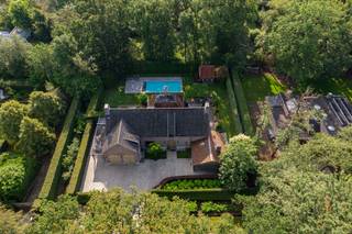 <p>Gelegen in een rustige en elegante laan met karaktervolle villa’s op royale percelen, bevindt zich deze instapklare villa met verwarmd buitenzwembad. De woning geniet van een uitzonderlijke ligging in een groene, natuurrijke omgeving, pal aan het Zoerselbos, waar rust en privacy centraal staan. Tegelijk zijn alle nodige voorzieningen en een vlotte bereikbaarheid binnen handbereik, wat deze locatie tot een zeldzame combinatie van natuur en comfort maakt.<br /><br /></p>
<p><strong>Indeling:<br /></strong><br />Inkomhal met gastentoilet. Enerzijds is er toegang tot de leefkeuken, anderzijds tot de leefruimte. De leefruimte is ingedeeld in een ruim salon met open haard, open tot in de nok van het dak, een eetkamer en een aparte bureauruimte. Deze laatste biedt op haar beurt toegang tot de dubbele inpandige garage en de wasplaats/technische ruimte.</p>
<p>De luxueus ingerichte leefkeuken is hypergeïnstalleerd en voorzien van alle hedendaags comfort (ijskast, diepvriezer, wijnkast, inductiekookplaat, dubbele dampkap, ruime traditionele oven, combi-oven, stoomoven, warmhoudlade, dubbele spoelbak en aanrecht- en werk-/eeteiland in composiet, …).</p>
<p>Vanuit de keuken is er toegang tot het overdekte en afsluitbare terras met open haard, dat op zijn beurt toegang biedt tot een extra garage. Aan de andere zijde van de woning bevindt zich bovendien een ruime carport.</p>
<p><strong>Verdieping:<br /></strong><br />Overloop met toegang tot de hoofdslaapkamer met dubbele dressing en een ruime badkamer en suite (ligbad, inloopdouche, dubbele lavabo en toilet). Slaapkamers 2 en 3 beschikken over een aangewerkt bureau, een ingemaakte kastenwand en een communicerende badkamer met twee lavabo’s, ligbad en douche. Verder is er nog slaapkamer 4, een aparte wasplaats en een nachttoilet op de gang.</p>
<p>De mooi aangelegde tuin met recent vernieuwde terrassen is volledig omheind. Het zwembad wordt verwarmd via een warmtepomp.<br /><br />Beschikbaar vanaf zomer 2027.</p>
<p><strong>Bijzonderheden:<br /></strong><br />Automatische toegangspoort – bevloering in natuursteen en parket – vloerverwarming en centrale verwarming op mazout (Buderus) – dubbele beglazing – houten ramen – hoge plinten – ventilatiesysteem D – airconditioning – dakisolatie – geïsoleerde bergzolder – recent uitgevoerde schilderwerken – overal LED-verlichting – kruipruimte – alarm en buitenalarm – camerabewaking – domotica – elektriciteit conform – <strong>BESCHIKBAAR </strong>zomer 2027 - EPC-label B- 133 kWh/m² – Vg-Wp-Vv-Gvkr-Gmo-Gworg.</p>
