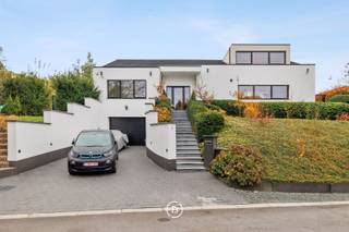 Gelegen op een onderhoudsvriendelijk terrein van 1.029 m² in een doodlopende straat bevindt zich deze moderne villa. De woning werd in 2019 smaakvol gerenoveerd en voldoet ondertussen aan de energiedoelstelling van 2050. <br /><br />De bewoonbare oppervlakte van 480 m² is als volgt ingedeeld:<br /><br />0: Inkomhal met gastentoilet, ruime woon- en eetkamer voorzien van open haard en onmiddellijke toegang tot het overdekte terras, volledig uitgeruste open keuken. Drie slaapkamers (16, 9 en 9 m²) met badkamer voorzien van wastafel, toilet en douche, en een mastersuite (18 m²) voorzien van dressing en badkamer met dubbele wastafel, douche en ligbad.<br /><br />+1: de bovenverdieping kan dienen als ontspanningsruimte/bureel met ruim terras of kan verder ingericht worden tot 2 slaapkamers met badkamer (leidingen aanwezig).<br /><br />-1: de kelderverdieping omvat een dubbele garage (achter elkaar), een voorraadruimte en technische ruimte. De rest van de woning is voorzien van een kruipkelder.<br />De buitenomgeving (zuidoost georiënteerd) is onderhoudsvriendelijk en wordt gekenmerkt door een overdekt terras, buitendouche, een tuinhuis en een ruime oprit.
