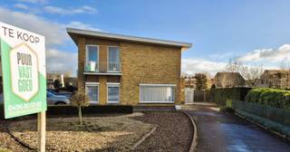 Op de hoek van de Torhoutsesteenweg en de Sint-Elooistraat staat deze vrijstaande modernistische woning uit 1962, vroeger een dagbladhandel. Ze...