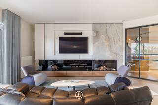 Sublimely finished ground floor design apartment, fully developed and realized by Huis Creemers, located in the historic heart of Tongeren.<br /><br />Sale under registration fees. No VAT!<br /><br />The apartment is part of the enclosed Residence 'Ilex', surrounded by a beautifully landscaped, mature garden. You live within walking distance of the center of Tongeren, with all amenities within reach.<br /><br />This recent apartment (built in 2020) offers a generous living area of 165 m² and has a beautiful southwest-facing terrace of 32 m². The interior concept is consistently carried through in every space, with a refined harmony between walnut wood, lacquer, and natural stone.<br /><br />The light-filled living space is equipped with custom-made cabinets, discreet integrated techniques, and a cozy gas fireplace, creating a sleek yet warm overall look.<br /><br />Central in the apartment is a generous kitchen island in quartzite natural stone. The kitchen is equipped with high-quality appliances, including a BORA hob, Siemens oven with steam function, Quooker tap, Liebherr fridge with ice cube function, and a built-in wine climate cabinet.<br /><br />The spacious bathroom combines aesthetics and functionality and is finished with custom-made Corian, a Whirlpool bath, walk-in shower, and high-quality Japanese toilet installation.<br /><br />Furthermore, the apartment has two bedrooms, one of which is currently furnished as an office or guest room. The master bedroom includes a stylish integrated built-in dressing room. A practical laundry room/storage room is discreetly integrated into the overall concept.<br /><br />On a technical level, this apartment is fully equipped for the future with an advanced home automation system, alarm system, and camera surveillance. With an energy performance level of E45 (77 kWh/m²·year) and energy label A, the property combines luxurious living comfort with excellent energy efficiency.<br /><br />The whole is completed by an additional parking space within the secure residence. For an additional fee, a very spacious private garage box can be purchased. An exceptional living opportunity for those who want to combine design, comfort, and tranquility in a prime location.