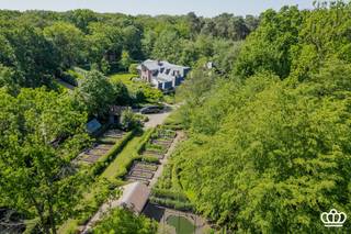<p><span>In het Mastenbos, op een steenworp van het dorpscentrum van Kapellen, bevinden zich deze uitzonderlijke en prachtig gerenoveerde voormalige koetshuis en orangerie van het voormalige “kasteel Mastenhof” op een domein van ca. 2 hectare. </span></p><p><span>Het koetshuis werd omgetoverd tot een luxueuze villa die sfeer en karakter ademt, deze beschikt over 6 slaapkamers en 3 badkamers. De leefruimtes, omvatte een ruime zitkamer, een eetkamer, een bureau en een grote leefkeuken als het centrale hart van het huis met directe toegang tot de knusse “binnentuin”. Het geheel kenmerkt zich door een perfecte combinatie van authentieke elementen en hedendaags wooncomfort. De wellness voorzieningen maken het plaatje compleet.</span></p><p><span> </span></p><p><span>Verder beschikt de eigendom over een fraaie en luxueus gerenoveerde oranjerie van 183 m². Deze omvat een royale leefruimte met openhaard, aparte moderne keuken en op de verdieping een suite met slaapkamer, dressing en ensuite badkamer, dit alles onder een glazen dak. Vanwege de grote raamdeuren geniet men een prachtig uitzicht over de prachtige tuin. Ideaal als gastenverblijf.</span></p><p><span> </span></p><p><span>De natuur op en rond het domein is bijzonder waardevol en vormt een uniek geheel van bossen, weide en natuurlijke waterpartijen.<br />Verder bevinden zich in de prachtige, in typische Engelse stijl aangelegde tuin, nog een serre, kippenren, moestuinbakken, etc..</span></p><p><span>Direct aan de villa een knusse en fraai aangelegde “binnentuin” met diverse terrassen.</span></p><p><span>Een uitzonderlijk eigendom waar authenticiteit, comfort en natuur elkaar moeiteloos vinden.</span></p><p><span> </span></p><p><span> </span></p>