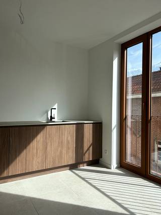 Aankoop onder 6% BTW mogelijk!<br /><br />Gelegen op een uitstekende locatie in Brasschaat - Mariaburg, bevindt zich dit stijlvol afgewerkte hoekappartement met een privatief terras. Het appartement maakt deel uit van een kleinschalig en duurzaam nieuwbouwproject, nl. residentie BO.<br />Bij het betreden van het appartement komt u via de inkomhal/nachthal in de verschillende ruimtes. Hier is ruimte voorzien voor een vestiaire en een apart toilet.<br />De woonkamer met open keuken vormt het hart van het appartement. De keuken is afgewerkt met fineerhouten fronten en een dekton werkblad, en uitgerust met kwalitatieve toestellen zoals een combi-oven, inductiekookplaat met geïntegreerde dampkap, vaatwasser en koelkast. Dankzij de grote raampartijen geniet de leefruimte van een aangename lichtinval en rechtstreeks toegang tot het zuidwestgericht terras. <br />De woonkamer is voorzien van een tegelvloer met vloerverwarming, wat zorgt voor een aangenaam en energiezuinig binnenklimaat. Verder beschikt het appartement over twee slaapkamers, een praktische berging, en een badkamer uitgerust met een moderne inloopdouche en lavabomeubel. <br />Technisch is het appartement volledig toekomstgericht: een privatief ventilatiesysteem, vloerverwarming, individuele zonnepanelen en een warmtepomp zorgen voor een zeer laag E-peil.<br />Troeven:<br />+ Nieuwbouw met hoogwaardige afwerking<br />+ Vloerverwarming op warmtepomp<br />+ Zonnepanelen en ventilatiesysteem D<br />+ Ruim terras aan de leefruimte<br />+ Twee slaapkamers<br />+ Energiezuinig en toekomstbestendig<br />+ Lift in het gebouw<br />+ Mogelijkheid tot aankoop van carport(s)<br />Dit appartement is ideaal voor eigen bewoning of als investeringsvastgoed, mede dankzij het verlaagde btw-tarief van 6% in het kader van sloop en heropbouw.