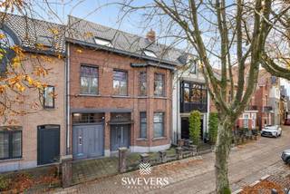 Voor meer info en foto’s, surf naar www.swevers.be – In het hart van Mol staat dit karaktervolle herenhuis uit 1933 met een bewoonbare oppervlakte van 269 m², verdeeld over drie verdiepingen. De woning biedt zes slaapkamers, twee badkamers en tal van authentieke elementen, gecombineerd met modern comfort zoals zonnepanelen, airco en een recente gasketel (2021). Op het gelijkvloers vind je een zeer ruime leefruimte opgedeeld in een voorkamer, centrale zithoek en eetkamer, gevolgd door een keuken met berging, apart gastentoilet en een inpandige stadsgarage. Het zuidgerichte perceel van 3a30ca beschikt over een onderhoudsvriendelijk overdekt terras en is verder momenteel ingericht als basketpleintje maar perfect om te vormen tot een knusse stadstuin. Dankzij de centrale ligging op wandelafstand van winkels, scholen, horeca en openbaar vervoer is dit pand ideaal voor gezinnen of wie ruimte zoekt voor werk of hobby’s. Extra troeven zijn de kelder van 45 m² en parkeermogelijkheid op de oprit of in de straat. Voor meer informatie, bel 011 255 155. Bron bewoonbare oppervlakte: EPC – verslag.