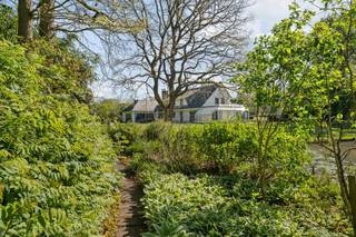 Charmante villa met ruime uitbreidingsmogelijkheden op een uniek privé-domein grenzend aan natuurgebied te Schilde<br /><br />In één van de meest gegeerde en residentiële buurten van Schilde, discreet gelegen aan het einde van een doodlopende straat, bevindt zich deze karaktervolle villa op een perceel van 4968m². Een locatie waar rust, privacy, natuurbeleving en comfort naadloos samenkomen.<br /><br />Indeling gelijkvloers:<br />De villa verwelkomt u via een ruime en lichtrijke inkomhal met vestiaire en gastentoilet. Vanuit hier bereikt u de aangename leefruimte met open haard en grote raampartijen, die zorgen voor een prachtig uitzicht op de fraai aangelegde tuin. Aansluitend bevindt zich een sfeervolle leefveranda, volledig omringd door schuiframen en voorzien van automatische zonnescreens, zodat u het hele jaar door geniet van een maximale lichtinval en een harmonieus zicht op het groen.<br /><br />De volledig uitgeruste keuken biedt eveneens zicht op en directe toegang tot het terras en wordt vergezeld door een praktische berging. Aansluitend bevindt zich een tweede gezellige leef- en eetruimte, voorzien van een houtkachel, wat deze ruimte bijzonder warm en uitnodigend maakt. Tevens is er een aparte bureauruimte, ideaal voor wie praktijk- of kantooractiviteiten aan huis wenst. De inpandige garage met automatische poort biedt plaats aan twee voertuigen.<br /><br />Eerste verdieping:<br />De nachthal leidt naar de master bedroom met ensuite badkamer, aangevuld met drie comfortabele, volwaardige slaapkamers. Daarnaast is er een tweede badkamer met douche en een bijzonder ruime, functionele wasplaats.<br /><br />Tuin en buitenbeleving:<br />De zuidwest-georiënteerde tuin vormt een ware oase van rust, met weidse vergezichten en een bijzonder harmonieuze groenbeleving. De tuin werd smaakvol aangelegd.<br /><br />Bijzonderheden:<br />- Maximale privacy, prestigieuze ligging & ideale zonoriëntatie<br />- Renovaties: 1997 (aanbouw leefruimte) – 1999 (gedeeltelijk buitenschrijnwerk)<br />- Verwarming op aardgas (Viessmann) via radiatoren en convectoren<br />- Dubbele beglazing (hout & aluminium)<br />- Rolluiken aanwezig<br />- Videofonie & automatische toegangspoort<br />- Oprit met plaats voor ca. 6 wagens<br />- Bergzolder toegankelijk via vlizotrap