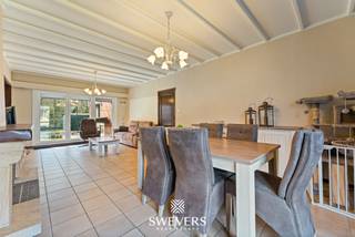 Voor meer info en foto’s, surf naar www.swevers.be – Op een centrale locatie in Heusden-Zolder vinden we deze knusse open bebouwing met een warme, huiselijke uitstraling. De gelijkvloerse woning werd gebouwd in 1970 en biedt een bewoonbare oppervlakte van ca. 138 m². Ze bevindt zich in een op te moderniseren staat, maar beschikt over een solide structuur en enkele reeds vernieuwde elementen zoals nieuwe ramen, dakisolatie, een zonneboiler en een conforme elektrische installatie.<br />Via de inkomhal bereikt u de lichtrijke woonkamer van 28,50 m², die het hart vormt van de woning en biedt voldoende plaats voor een gezellige zit- en eetruimte. Grote raampartijen zorgen voor veel natuurlijke lichtinval en een aangenaam zicht op de tuin. Aansluitend ligt de keuken van 7,20 m², die mogelijkheden biedt om naar eigen smaak te vernieuwen of eventueel open te werken. Naast de keuken bevindt zich een praktische berging/wasplaats, grenzend aan de inpandige garage van 15 m². Via de nachthal bereikt u drie slaapkamers van respectievelijk 12 m², 10,50 m² en 8,80 m², een badkamer en een apart toilet.<br />Het perceel van 761 m² met zuidwestelijke oriëntatie biedt een aangename tuin waar u volop van de zon kan genieten. Dankzij het omliggende groen is het hier heerlijk wonen. Tegelijk bevindt de woning zich op een gunstige locatie: de snelweg ligt op 3,5 km, winkels, scholen en horeca op ongeveer 2 km en openbaar vervoer op slechts 300 meter.<br />Deze woning vormt een uitstekende kans voor wie op zoek is naar een charmante thuis met potentieel op een centrale locatie. Voor meer informatie, bel 011 255 155. Bron bewoonbare oppervlakte: EPC – verslag.