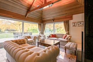 Charmante villa met ruime uitbreidingsmogelijkheden op een uniek privé-domein grenzend aan natuurgebied te Schilde<br /><br />In één van de meest gegeerde en residentiële buurten van Schilde, discreet gelegen aan het einde van een doodlopende straat, bevindt zich deze karaktervolle villa op een uitzonderlijk perceel van ca. 14.990 m², waarvan een deel ingericht werd voor het houden van dieren met eigen verblijf. Een locatie waar rust, privacy, natuurbeleving en comfort naadloos samenkomen.<br /><br />Indeling gelijkvloers:<br />De villa verwelkomt u via een ruime en lichtrijke inkomhal met vestiaire en gastentoilet. Vanuit hier bereikt u de aangename leefruimte met open haard en grote raampartijen, die zorgen voor een prachtig uitzicht op de fraai aangelegde tuin. Aansluitend bevindt zich een sfeervolle leefveranda, volledig omringd door schuiframen en voorzien van automatische zonnescreens, zodat u het hele jaar door geniet van een maximale lichtinval en een harmonieus zicht op het groen.<br /><br />De volledig uitgeruste keuken biedt eveneens zicht op en directe toegang tot het terras en wordt vergezeld door een praktische berging. Aansluitend bevindt zich een tweede gezellige leef- en eetruimte, voorzien van een houtkachel, wat deze ruimte bijzonder warm en uitnodigend maakt. Tevens is er een aparte bureauruimte, ideaal voor wie praktijk- of kantooractiviteiten aan huis wenst. De inpandige garage met automatische poort biedt plaats aan twee voertuigen.<br /><br />Eerste verdieping:<br />De nachthal leidt naar de master bedroom met ensuite badkamer, aangevuld met drie comfortabele, volwaardige slaapkamers. Daarnaast is er een tweede badkamer met douche en een bijzonder ruime, functionele wasplaats.<br /><br />Tuin en buitenbeleving:<br />De zuidwest-georiënteerde parktuin vormt een ware oase van rust, met weidse vergezichten en een bijzonder harmonieuze groenbeleving. De tuin werd smaakvol aangelegd, inclusief een fraaie vijverpartij, en beschikt bovendien over een bijgebouw/stal voor het houden van dieren — ideaal voor paarden- of dierenliefhebbers, of voor wie een hobbyproject wenst te realiseren.<br /><br />Bijzonderheden:<br />- Maximale privacy, prestigieuze ligging & ideale zonoriëntatie<br />- Renovaties: 1997 (aanbouw leefruimte) – 1999 (gedeeltelijk buitenschrijnwerk)<br />- Verwarming op aardgas (Viessmann) via radiatoren en convectoren<br />- Dubbele beglazing (hout & aluminium)<br />- Rolluiken aanwezig<br />- Videofonie & automatische toegangspoort<br />- Oprit met plaats voor ca. 6 wagens<br />- Bergzolder toegankelijk via vlizotrap