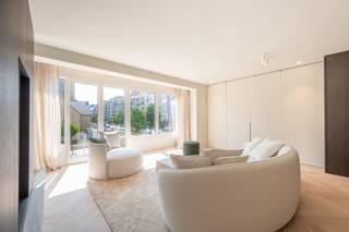 <p>Dit luxueuze appartement, met een oppervlakte van 140 m², ligt op een toplocatie tegenover de Heilig-Hartkerk. Het combineert licht, ruimte en elegantie, perfect voor liefhebbers van comfort.</p>
<p>De gezellige leefruimte straalt warmte en stijl uit, met een uitnodigende zithoek, een aparte eethoek en een verfijnde tunnelhaard die een harmonieuze verbinding vormt met de ruime open keuken. Dankzij de overvloed aan natuurlijke lichtinval en de open indeling ontstaat een modern loftgevoel, terwijl de slaapvertrekken een oase van rust en privacy bieden.</p>
<p>De drie slaapkamers, verbonden door een elegante gang, zijn elk voorzien van een luxueuze ensuite badkamer. Warme, natuurlijke materialen zoals eikenhout en travertin natuursteen creëren een serene en tijdloze sfeer.</p>
<p>Het interieur is tot in de puntjes afgewerkt met maatwerkmeubilair, zorgvuldig gekozen verlichting, verfijnde raamdecoratie en designmeubelen. De eikenhouten parketvloeren in visgraatmotief en de subtiele details versterken de exclusieve uitstraling van het appartement.</p>
<p>Elke ruimte is functioneel en efficiënt ontworpen, met volop opbergruimte en een discrete, ingebouwde wasplaats die via een aparte ingang bereikbaar is. Dit appartement biedt een unieke combinatie van luxe, comfort en doordacht design.</p>
<p></p>