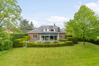 Cette charmante villa datant de 1961 se trouve à la périphérie du centre historique de Grimbergen. Elle est située sur un magnifique terrain de 1.951 m² exposé sud, le long de la Beiaardlaan. La villa a fait l'objet d'une rénovation en profondeur à partir des années '90, et se trouve toujours en excellent état.Le cabinet médical dispose d'une entrée séparée et comprend une salle d'attente, une salle d'examen et un grand bureau climatisé, équipé d'un bureau et d'armoires sur mesure Obumex, avec vue sur le jardin. La partie privée de la villa offre plus de 300 m² de surface habitable. Au rez-de-chaussée, vous trouverez un hall d'entrée spacieux, une salle à manger séparée, un salon avec une cheminée à gaz ouverte moderne de Depuydt, une cuisine entièrement équipée d'appareils haute-gamme donnant sur une grande salle de vie très lumineuse s'ouvrant sur le jardin et dotée de climatisation. Au 1er étage, vous trouverez cinq chambres et deux salles de bains. La chambre principale est équipée de climatisation.La maison est presque complètement sous caves et dispose d'un garage pour 2 voitures avec porte automatique. Chauffage au gaz (chaudière Viessmann) et chauffe-eau solaire.Une opportunité idéale pour ceux qui recherchent à la fois un cadre de vie agréable et la possibilité d'exercer une profession libérale dans un environnement agréable et facilement accessible. Registre des mesures: non