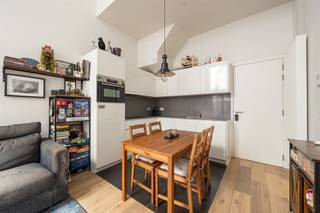 <p><span>Op zoek naar een tof appartement midden in de stad? Hier krijg je een lichte leefruimte met hoge plafonds, een gezellige stadskoer, een achteraan gelegen slaapkamer én een extra bureel op een extra verdieping. De warme parketvloer, nette afwerking en ligging vlak bij de Ossenmarkt krijg je er zo bij!</span></p><p><span>Veel licht, hoge plafonds & parket</span></p><p><span>Je komt binnen in de leefruimte met open keuken, waar de hoge plafonds (4.20m!) meteen voor een fijn ruimtegevoel zorgen. De mooie parketvloer loopt door in de zithoek en maakt het geheel warm en gezellig. Dankzij de hoge ramen valt er bovendien lekker veel daglicht binnen.</span></p><p><span>De witte keuken is strak en praktisch ingericht, met veel kastruimte, een grijs en ruim werkblad, spoelbak, kookplaat en ingebouwde oven. Er is plaats voor een eettafel vlakbij de keuken, terwijl je aan de andere kant makkelijk een ruime zithoek installeert. Een fijne open leefplek dus, zonder dat keuken en salon in elkaars weg zitten.</span></p><p><span>Vanuit de leefruimte stap je rechtstreeks de stadskoer op. Met een tafel, wat stoelen en groen maak je hier een gezellige buitenplek waar je bij mooi weer heerlijk buiten kunt eten.</span></p><p><span>Via de hal wandel je naar het gastentoilet, de slaapkamer en de badkamer. De slaapkamer ligt rustig achteraan en heeft dezelfde warme parketvloer. Extra leuk: ook van hieruit heb je rechtstreeks toegang tot de stadskoer.</span></p><p><span>De badkamer is strak afgewerkt met een grote inloopdouche, een dubbel lavabomeubel in houtlook en een grote spiegelkast. Alles wat je nodig hebt, zonder overbodige franjes. Ideaal!</span></p><p><span>Een verdieping extra</span></p><p><span>De houten spiltrap in de hal brengt je naar boven, waar je nog een verrassend grote extra ruimte hebt. Het aparte bureel is eveneens afgewerkt met parket, krijgt natuurlijk licht binnen en biedt meer dan genoeg plaats voor een fijne thuiswerkplek. Een hobbykamer, dressing of logeerplek kan hier natuurlijk evengoed.</span></p><p><span>Op de overloop is ook plaats voorzien voor de wasmachine, netjes uit de leefruimte. En spullen die je niet elke dag nodig hebt? Die kun je kwijt in de kelder. Voor de fiets is er een gemeenschappelijke fietsenstalling in het gebouw voorzien.</span></p><p><span>Midden in de stad </span></p><p><span>Je woont hier pal in het historische centrum van Antwerpen, vlak bij de gezellige Ossenmarkt en midden in de universiteitsbuurt. Terrasjes, restaurants, koffiebars en winkels heb je hier voor het uitkiezen, en ook de Paardenmarkt en Stadswaag liggen vlakbij. Voor tram en bus hoef je niet ver en ook het Centraal Station bereik je makkelijk te voet of met de fiets. Een echte stadsplek dus, met zowat alles binnen handbereik. </span></p><p><span> </span></p>