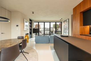 <p><span> </span></p><p><span>Luxe, rust en ruimte midden in het bruisende centrum. Dit sublieme penthouse ligt in de prestigieuze Henri Van Heurckstraat, pal tussen de Graanmarkt, het Theaterplein en het stijlvolle Botanic Sanctuary. Je wandelt zo naar de Schuttershofstraat, Mechelsplein en de leukste restaurants van de stad. Mét twee riante terrassen, hoogwaardige materialen, veel privacy, domotica en de mogelijkheid tot aankoop van twee staanplaatsen met laadpaal.</span></p><p><span> </span></p><p><span>Stijlvol & comfortabel</span></p><p><span>Je betreedt het penthouse via de modern afgewerkte veiligheidsdeur. De inkomhal met vestiaire en gastentoilet leidt je naar een lichte leefruimte met gashaard en epoxyvloer. Grote harmonicadeuren verbinden de leefruimte met het enorme terras achter en vooraan. De open keuken is uitgerust met onder andere een wijnklimaatkast, stoomoven, inductiekookplaat en extra koelkast, afgewerkt met notelaarhouten kasten en een strak werkblad.</span></p><p><span> </span></p><p><span>Rust & privacy met luxegevoel</span></p><p><span>De mastersuite heeft kamerhoge ingemaakte kasten en directe toegang tot het terras. Ensuite vind je een elegante luxe badkamer met inloopdouche, dubbele design wasbak, maatwerk spiegels en toilet. De tweede kamer doet nu dienst als bureau, maar heeft aansluitend een bergkamer met voorzieningen voor een extra badkamer. Zowel voor- als achteraan zijn er ruime terrassen (ca 60 m² & ca 12,5 m²), met uitzicht op de gemeenschappelijke binnentuin en de stad. Dankzij de slimme oriëntatie geniet je hier van licht en privacy, de hele dag door.</span></p><p><span> </span></p><p><span>Wonen tussen het theaterplein en botanische tuin</span></p><p><span>Rust, privacy én toch midden in het leven van de stad. In de Henri Van Heurckstraat woon je tussen het Theaterplein, de Meir, het Mechelseplein en het prachtige Botanic Sanctuary. Alle winkels, horeca en cultuur op wandelafstand. Openbaar vervoer (metro Meir, tram op de Leien en Centraal Station) bereik je binnen de 5 minuten te voet.</span></p><p><span> </span></p><p><span>Maatregelenregister: in aanvraag</span></p><p><span> </span></p>