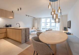 De inkomhal beschikt over een gastentoilet en vestiaire. De leefruimte is voorzien van een open ingerichte keuken en een aangrenzende eetruimte. Er zijn 2 volwaardige slaapkamers met ingemaakte kasten waarvan één met eigen douchekamer. Daarnaast is er ook nog kleinere slaapkamer met stapelbed en een aparte Badkamer. Aan de achterzijde bevindt zich een terras. <br />Verder zijn er ook een kelder en fietsenberging aanwezig. <br /><br />Mogelijkheid tot aankoop van de meubels.