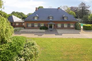 <p><strong><em>Villa élégante (584 m²) avec 7 chambres, 2 dressings, salle de bain et salle de douche, bureau + espace de travail, double garage, grenier, cave, grande terrasse avec piscine et magnifique jardin de parc avec court de tennis sur une parcelle de 51a 14ca offrant une grande intimité à Herent.</em></strong><br /><strong><em>Possibilités certaines pour une maison kangourou, bureau, cabinet ou profession libérale.</em></strong></p><p>Située dans un endroit calme et très privé, cette villa raffinée dévoile une habitation spacieuse où chaleur et générosité se mêlent naturellement. Avec ses vastes espaces de vie, ses sept chambres, ses deux dressings, ses espaces de travail et son jardin de parc étendu, cette maison constitue un lieu de vie particulièrement accueillant pour ceux qui recherchent confort, élégance et polyvalence.</p><p>Le large hall d’entrée avec vestiaire et toilette invités mène à un séjour lumineux en forme de L, agrémenté de pierre naturelle, d’un foyer au gaz intégré et de mobilier sur mesure apportant calme et raffinement. Les grandes baies vitrées offrent une vue superbe sur le jardin et un accès direct à la vaste terrasse.<br />La cuisine attenante, aménagée avec goût, présente des plans de travail en pierre naturelle, un parquet massif et une charmante baie vitrée avec coin repas donnant sur la verdure.</p><p>Au rez-de-chaussée se trouve également un bureau spacieux de 31 m², complété par un espace de travail de 41 m² équipé de l’air conditionné. Cette aile est idéale pour une pratique, une profession libérale ou un bureau à domicile.<br />Le double garage et l’allée permettent un stationnement confortable.</p><p>Le premier étage dévoile un hall de nuit central avec toilette séparée, une salle de bain rénovée en pierre naturelle avec baignoire et douche, une salle de douche distincte et pas moins de sept chambres, dont certaines avec placards intégrés et lavabo. La chambre principale dispose de deux dressings séparés, renforçant la sensation d’espace et de luxe.</p><p>Au-dessus, un grand grenier de 88 m² offre des possibilités d’extension pour ceux qui souhaitent encore davantage d’espace.<br />La cave (30 m²) comprend notamment une installation de chauffage récemment remplacée, un adoucisseur d’eau et une cave à vin réfrigérée. Un vide sanitaire est également présent.</p><p>À l’extérieur, la terrasse de 82 m² constitue un lieu de détente privilégié, directement relié à la piscine chauffée orientée plein sud.<br />Le jardin de parc paysager respire la tranquillité et l’intimité, et comprend un court de tennis entièrement aménagé, un atout supplémentaire rare sur un domaine de cette qualité.</p><p>Atouts supplémentaires :<br />EPC : 244 kWh/m²/an (label C) – Toiture en ardoises naturelles rénovée en 2015 – Installation de chauffage récemment remplacée.<br />Puits d’eau souterraine.<br />Adoucisseur d’eau.<br />Système d’alarme – vidéophone.</p><p>L’emplacement combine calme et accessibilité : le centre d’Herent et toutes ses commodités sont accessibles à vélo, tout comme Louvain. L’accès à l’E314 se trouve à dix minutes, et Bruxelles est facilement joignable. La propriété est accessible via une allée privée, renforçant encore la discrétion du lieu.<br />Un cadre unique pour vivre et travailler en toute sérénité.</p>