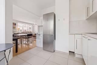 Op een steenworp afstand van de renbaan van Boitsfort kunt u dit bijzondere pand ontdekken met een totale oppervlakte van ±175 m² en een bijzonder veelzijdige indeling.<br />Op de eerste verdieping bevindt zich een aangenaam appartement met 3 slaapkamers van ±126 m², terwijl de begane grond beschikt over een aparte ruimte, ideaal voor het uitoefenen van een vrij beroep, het inrichten van een kantoor of zelfs om apart te verhuren als studio/kantoor. Een zeldzame indeling waarmee u wonen en werken gemakkelijk kunt combineren, terwijl het tevens een reëel aanvullend potentieel biedt. Het pand beschikt eveneens over een garagebox met een parkeerplaats ervoor, verplicht bij aan te kopen voor 50.000€. Een pand met talrijke mogelijkheden, gelegen in de gewilde wijk van de renbaan van Boitsfort, vlakbij groenvoorzieningen en voorzieningen. EPC: G.<br /><br /><strong><em>DUPLEX B1</em></strong><br /><span>Begane grond links:</span> Kantoorruimte of studio van ± 50 m²<br /><br /><span>1e verdieping links:</span><br />
<ul>
<li>Inkomhal</li>
<li>Woonkamer ± 30 m² met parketvloer</li>
<li>Volledig uitgeruste open keuken die uitkomt op de woonkamer</li>
<li>Toilet</li>
<li>Doucheruimte met wasruimte</li>
<li>Slaapkamer ± 20 m²</li>
<li>Slaapkamer ± 18 m²</li>
<li>Slaapkamer ± 10 m² met balkon</li>
</ul>
Kelder<br />Garagebox + parkeerplaats ervoor