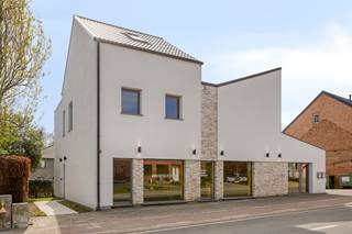 <h2><strong>Moderne, lichtovergoten woon-werk opportuniteit op strategische locatie te Betekom</strong></h2><p>Wonen en werken: twee invullingen onder één dak met tal van voordelen die elkaar versterken. Achter deze moderne gevel schuift namelijk een pand dat uitblinkt in ruimte, licht en flexibiliteit, met een doordachte indeling die zowel jouw privéleven als professionele activiteit laten floreren. Een combinatie om van te dromen, en jij kan er in wonen.</p><p>Thuis wordt je verwelkomd met een open gevoel: een woonkamer met hoge plafonds en een aangename lichtinval. Deze vloeit harmonieus over in de keuken, die volledig is uitgerust en uitkijkt op jouw zalig zonnige, zuidgerichte tuin met modern aangelegd terras en een heerlijk stukje gras dat op een subtiele manier de brug slaat tussen het woon- en werkgedeelte. Gelegen op een perceel van ca. 5 are en waar je in alle rust kan genieten van het buitenleven. Met drie volwaardige slaapkamers, een praktische wasplaats en een ruime badkamer voorzien van zowel bad als inloopdouche, vormt deze woning een ideale thuisbasis voor wie graag ruim en zorgeloos leeft.</p><p>Het handelsgedeelte – via een aparte ingang te betreden – is niet alleen een grote troef, maar ook een ware eye-catcher. Wat je opvalt is de open ruimte, gedefinieerd door een houten structuur, met gepolierde betonvloer en lichtovergoten op beide etages. De combinatie van vloerverwarming met de aanwezigheid van onder meer een keuken en kantoorruimte maken van deze stek een uiterst praktische en veelzijdige werkplek. Of je nu een eigen praktijk wenst te lanceren of een kantoor aan huis wilt organiseren: hier vind je de ruimte én de uitstraling om professioneel te groeien, zonder in te boeten aan privacy. De ligging vertaalt zich bovendien in een uitstekende bereikbaarheid én een sterke commerciële visibiliteit. Tegelijk zijn winkels, bakker en school vlakbij, en steden als Aarschot nabij. </p><p>En ook energetisch sta je sterk: met 25 zonnepanelen en een gunstig EPC zitten deze kosten ook alweer helemaal mee. Als bijkomende opportuniteit kan je de naastgelegen bouwgrond optioneel aankopen. Deze is niet inbegrepen in de vraagprijs en opent perspectieven voor extra parkeergelegenheid, uitbreiding of een invulling op maat van jouw toekomstplannen.</p><p>Kortom, een kantoor waar je met plezier je dagen spendeert, naast een woning die je steevast charmeert. Graag jouw toekomstige woon-werkplek bezoeken? Geef Jes dan snel een seintje, en wij doen de rest.</p><figure><div></div></figure>