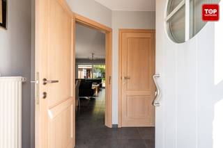 Deze instapklare woning is gelegen in een rustige, kindvriendelijke woonwijk en bevindt zich in een doodlopende straat. <br />De woning zich op slechts een steenworp van alle nodige voorzieningen zoals scholen, winkels en openbaar vervoer. Dankzij de nabijheid van de R4 geniet u van een uitstekende verbinding van en naar Gent en omliggende gemeenten.<br /><br />Bij het betreden van de woning komt u binnen in de inkomhal met apart toilet. Verder gaat u via de inkomhal naar de lichtrijke woonkamer, de inpandige garage (met sectionale poort) en de bovenverdieping. <br />De ruime leefruimte baadt in het natuurlijke licht en kijkt uit op de groene tuin, aansluitend aan de woonkamer bevindt zich de volledig uitgeruste keuken, voorzien van alle hedendaagse comfort en met directe toegang tot het aangelegd terras met recente zonneluifel. De woning is voorzien van rolluiken, ook boven aan de dakramen, een waterontkalker en centraal stofzuigersysteem.<br /><br />De tuin is onderhoudsvriendelijk aangelegd. Achteraan de tuin staat een praktisch tuinhuis, uitgerust met zonnepanelen. Extra troef: de tuin grenst aan een groenzone, wat het uitzicht en de privacy ten goede komt.<br /><br />Op de eerste verdieping bevinden zich drie volwaardige slaapkamers (allemaal met parket voorzien) en een badkamer met zowel een ligbad als een douche. Daarnaast beschikt de woning over een ruime zolder, ideaal voor extra bergruimte.<br /><br />Beschikbaar uiterlijk 30/6/26.<br /><br />Contacteer Top Vastgoed voor een bezoek op 0475 700 700.