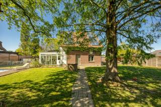 Op zoek naar een unieke woning met karakter, ruimte én moderne comfortvoorzieningen? Dit voormalige boswachtershuis werd in 1996 volledig gerenoveerd en combineert authenticiteit met hedendaags wooncomfort. Met een bewoonbare oppervlakte van 203 m² en een prachtig aangelegde tuin is dit een ideale thuis voor gezinnen of liefhebbers van rust en ruimte.<br /><br />Bij het binnenkomen geniet u meteen van de lichtrijke veranda (2014), waar u dankzij het prachtige zicht op de tuin elk seizoen tot rust komt. De open keuken sluit naadloos aan op de gezellige eetkamer en leefruimte, wat zorgt voor een warme en uitnodigende sfeer. Vanuit de leefruimte bereikt u een charmant tussenverdiep dat perfect dienst kan doen als bureau, hobbyruimte of speelhoek.<br /><br />Op de eerste verdieping bevinden zich drie ruime slaapkamers en een comfortabele badkamer uitgerust met ligbad, douche en dubbele lavabo. Ook de tweede verdieping werd volledig afgewerkt en biedt tal van mogelijkheden, waaronder het creëren van een extra slaapkamer, studio of multifunctionele ruimte.<br /><br />De volledig omheinde tuin vormt een heerlijke plek om te ontspannen, met een gezellig terras, een sfeervolle buitenlounge en een zwembad.<br /><br />Extra troeven:<br /><br />- Achteringang met automatische poort<br />- Ruime garage/werkplaats<br />- Gezellige buitenlounge<br />- 16 zonnepanelen<br />- EPC-label C<br />- Droge kelder<br /><br />Deze locatie geniet een uitstekende bereikbaarheid en een vlotte verbinding naar Antwerpen en de E313. De buurt combineert het comfort van talrijke winkels, scholen en openbaar vervoer op wandelafstand met de nabijheid van groene ontspanningsmogelijkheden zoals Fort 2. Een aangename en centrale woonomgeving met alle voorzieningen binnen handbereik.