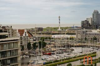 <strong>Exclusief wonen met panoramisch uitzicht</strong><br /><br />Op de <strong>11de verdieping van Residentie Melinda</strong> bevindt zich dit ruime appartement van <strong>100 m²</strong>, waar licht, ruimte en een uitzonderlijke ligging centraal staan.<br />Vanuit de woonkamer geniet u van een <strong>adembenemend, vrij uitzicht op de jachthaven</strong>, aangevuld met een aangenaam zicht op zee.<br />Een unieke woonbeleving voor wie houdt van rust, licht en een prachtig panorama.<br /><br /><strong>Lichtrijke woonkamer met uitzicht op de jachthaven</strong><br />De royale leefruimte vormt het hart van het appartement. Dankzij de grote raampartijen baadt de woonkamer in het natuurlijke licht en geniet u dagelijks van een spectaculair uitzicht over de jachthaven en een glimp van de zee.<br />Een ideale plek om te ontspannen of gasten te ontvangen.<br /><br /><strong>Praktische keuken en comfortabele indeling</strong><br />De keuken bevindt zich aan de voorzijde van het appartement en biedt een praktische indeling met tal van mogelijkheden.<br />Verder beschikt het appartement over een <strong>badkamer met ligbad</strong>, een <strong>afzonderlijk toilet</strong> en een functionele nachthal.<br /><br /><strong>3 slaapkamers met zonnig terras</strong><br />Aan de rustige achterzijde bevinden zich <strong>3 volwaardige slaapkamers</strong>, die allemaal uitgeven op een <strong>zonnig terras</strong>.<br />Hier geniet u van een prachtig groen uitzicht op het Maria-Hendrikapark, het groene hart van Oostende, wat zorgt voor een aangename, rustige sfeer.<br /><br /><strong>Extra troef: autostandplaats mogelijk</strong><br />Voor wie extra comfort wenst, is er de <strong>mogelijkheid tot aankoop van een autostandplaats in de residentie</strong>. Een waardevolle meerwaarde in deze gegeerde omgeving.<br /><br /><strong>Energiezuinig appartement met gunstig EPC</strong><br /><br /><strong>Enkele kenmerken:</strong><br /><span>Bewoonbare oppervlakte: <strong>100 m²</strong></span><br /><span>3 slaapkamers met zonneterras aan de achterzijde</span><br /><span>Mogelijkheid tot aankoop van <strong>autostandplaats (nr 9)</strong></span><br /><span><strong>EPC: B – 143 kWh/m²/jaar</strong><br />Verwarming : aansluiting op het warmtenet</span><br /><span>Kadastraal inkomen: € 1.296</span><br /><span>Bouwjaar: 1973 </span><br /><br /><strong>Waarom kiezen voor dit appartement?</strong><br />Dit appartement is de ideale keuze voor wie op zoek is naar een <strong>ruim appartement te koop met zicht op de jachthaven</strong>, <strong>drie slaapkamers</strong>, <strong>zonneterras</strong> en een uitstekende ligging.<br />Dankzij de combinatie van een panoramisch uitzicht, een rustige achterzijde en een gunstige EPC-score vormt dit een interessante opportuniteit als vaste woonplaats, tweede verblijf of investering.<br /><br />Plan vandaag nog uw bezoek en ontdek zelf de unieke troeven van dit appartement in Residentie Melinda.<br /> 