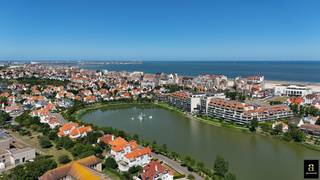 <p><span>Uniek aanbod: ge</span><span>legen op een uitzonderlijke locatie in het hart van Knokke, met een prachtig frontaal zicht op het Zegemeer, bevindt zich deze te renoveren villa op een perceel van circa 689 m².</span></p>
<p><span>De woning biedt een bijzonder interessante basis voor wie op zoek is naar een ruime villa op een absolute toplocatie en beschikt over vergunde plannen voor een grondige renovatie en uitbreiding. Het voorziene ontwerp omvat onder meer 5 slaapkamers en 4 badkamers, aangevuld met ruime leefvertrekken en een personenlift die de verschillende verdiepingen bereikt.</span></p>
<p><span>Ook op het vlak van parkeermogelijkheden biedt de villa uitzonderlijk veel potentieel. De bestaande kelderverdieping wordt behouden en voorziet in een ruime ondergrondse garage voor circa 2 à 3 wagens. Daarnaast is er op de oprit plaats voor meerdere auto's.</span></p>
<p><span>Dankzij de combinatie van het ruime perceel, de vergunde plannen, de royale parkeermogelijkheden en vooral het frontale zicht op het Zegemeer, vormt deze eigendom een bijzonder interessante opportuniteit voor wie een exclusieve villa wenst te realiseren op één van de meest gegeerde locaties van Knokke.</span></p>
<p><span>Een unieke renovatiemogelijkheid met uitzonderlijk potentieel, op wandelafstand van het Zegemeer, de Zeedijk en het centrum van Knokke.</span></p>