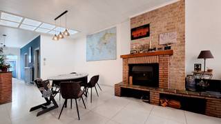 Op het gelijkvloers beschikt de woning over een inkomhal die toegang biedt tot de ruime leefruimte, voorzien van een sierhaard. Aansluitend...