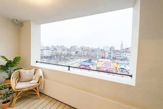 <p><b>Elegant Modern Apartment in Heart of Antwerp</b></p><p>Discover this stunning 63m² apartment located in vibrant Antwerp, offering contemporary comfort and style. This well-designed residential space spans 69m² total and features smart utilization of every square meter, making it an ideal choice for discerning buyers seeking modern urban living.</p><p><b>Key Features:</b></p><p>The property boasts <b>1 spacious bedroom</b> with beautiful views overlooking the lively Antwerp cityscape, including picturesque sightlines toward the historic city center. Large windows flood the space with natural light, creating an inviting and bright atmosphere.</p><p>The <b>open-plan kitchen and living area</b> showcases contemporary design with a sleek built-in kitchen featuring modern appliances, including a gas cooktop and integrated oven. The warm wooden flooring throughout creates a cohesive, welcoming aesthetic that flows seamlessly from the living spaces into the bedroom areas.</p><p><b>Bathroom & Facilities:</b></p><p>A <b>modern, well-appointed bathroom</b> features distinctive cork-textured walls with contemporary fixtures, including a rainfall shower and elegant basin. The bathroom design combines functionality with sophisticated style.</p><p><b>Building Amenities:</b></p><p>The building provides <b>secure, professional facilities</b> including accessible stairwells with modern white railings and emergency safety equipment, ensuring resident comfort and security.</p><p><b>Location & Views:</b></p><p>Positioned on an upper floor, this apartment offers <b>exceptional panoramic views</b> of Antwerp's vibrant cultural district, with direct sightlines to the famous Plaça square and surrounding architectural landmarks. The location provides excellent access to shops, restaurants, and cultural attractions.</p><p>This contemporary apartment represents an outstanding opportunity for those seeking stylish, modern living in one of Belgium's most dynamic cities.</p>