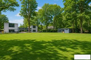 Unique villa designed by Lou Jansen on a spacious plot of over 3,000 m² in the residential area of De Lint<br /><br />This exceptional property, designed entirely by architect Lou Jansen (Turnhout School), is located on a beautiful south-facing plot within walking distance of the De Liereman nature reserve. It also enjoys an excellent location, just a 25-minute drive from both Eindhoven and Antwerp.<br /><br />The house is in need of complete renovation, but offers a wealth of possibilities thanks to its exceptional living area of 334 m² and versatile layout. Several interior walls can be moved, allowing you to redesign the spaces entirely to your liking.<br /><br />The current layout includes a spacious, bright living room and a kitchen, both overlooking the beautiful back garden and sun-drenched terrace. On the ground floor, there is also a bedroom with an en-suite bathroom and direct access to the garden. At the front, there is an office space that can serve as an extra bedroom if desired.<br /><br />Stairs on both the left and right sides of the house lead to the upper floor. Each side has two bedrooms and a shared bathroom.<br /><br />The indoor garage has space for two cars. The south-facing garden also features several charming chalets in good condition.<br /><br />In short, this is a unique renovation project that gives you the opportunity to completely customise an architecturally valuable home.