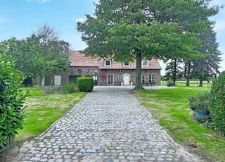 Uniek gelegen hoeve met naastliggende weilanden en tal van mogelijkheden. Op een uitzonderlijk rustige en groene locatie bevindt zich deze ruime hoeve op met een totale oppervlakte van 23650m². De woning biedt een aangename combinatie van ruimte, privacy en mogelijkheden, en is ideaal voor wie op zoek is naar een karaktervolle woning in een landelijke omgeving. <br /><br />De gelijkvloerse verdieping omvat een inkomhal met gastentoilet, een lichtrijke leefruimte met aparte eet- en zithoek, en een recent gerenoveerde keuken met eetplaats. Verder zijn er een badkamer met douche en dubbele lavabo, een slaapkamer, bureel, was- en bergruimte, een droge kelder en een garage. De woning beschikt daarnaast over verschillende extra bergruimtes en biedt hierdoor heel wat praktische mogelijkheden. Op de eerste verdieping bevinden zich vier slaapkamers, een nachthal met afzonderlijk toilet en een ruime bergzolder. Buiten geniet u van een grote, groene tuin met terras, twee ruime tuinbergingen, volledige privacy en naastliggende weilanden. Uniek aanbod!<br /><br />Troeven<br /><br />
<ul>
<li>AAA-ligging in een rustige en groene omgeving</li>
<li>Uiterst geschikt voor paarden of dierenliefhebbers.</li>
<li>2 regenwaterputten van elk 10.000 liter</li>
<li>Oprijlaan met afgesloten poort</li>
<li>2 tuinbergingen</li>
<li>Garage, kelder en meerdere bergruimtes</li>
<li>Ideaal voor wie ruimte, rust en privacy zoekt</li>
</ul>
<br />Deze op te frissen hoeve wordt verkocht zonder makelaar, volgens het concept van Smart Houses. Interesse of bezoek? Contacteer rechtstreeks de eigenaar via +32472259585