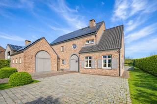 Gelegen in het charmante en landelijke Jeuk, een deelgemeente van Gingelom, bevindt zich deze uiterst kwalitatieve villa. De woning biedt een adembenemend vrij uitzicht en werd in 2005 gebouwd met oog voor duurzaamheid en energie-efficiëntie, waarbij uitsluitend gebruik is gemaakt van uiterst kwalitatieve materialen.<br /><br />De omgeving ademt rust en natuur, met uitgestrekte velden en een sfeervolle dorpskern in de nabijheid. Toch geniet u hier van een vlotte verbinding naar Sint-Truiden, Hasselt en de E40, waardoor steden als Brussel en Luik binnen handbereik liggen. Hier woont u in een oase van rust zonder in te boeten op bereikbaarheid en comfort.<br /><br />INDELING<br />Wanneer de dubbele elektrische poort zich opent, wordt u meteen betoverd door deze prachtige villa op een perceel van 1.250 m². De hoogwaardige afwerking straalt al van buitenaf: een perfect onderhouden tuin, een charmant aangelegd terras en een imposante gevel.<br /><br />Bij binnenkomst zet deze eerste indruk zich moeiteloos verder. De hal verwelkomt u met een luxueuze blauwe stenen vloer en een majestueuze eiken trap. De elegante boogvormige doorgangen geven een harmonieus karakter aan de woning.<br /><br />De woonkamer straalt warmte en gezelligheid uit, met (2 cm dik) eiken parket en een Hoog Rendement kachel van Flam. Grote ramen zorgen voor een overvloed aan natuurlijk licht en bieden toegang tot het overdekte terras, waar u in alle privacy kunt genieten van de tuin.<br /><br />De leefkeuken is een waar pronkstuk: een hoogwaardige Miele-uitrusting met onder andere een oven, steamer, koffiemachine en bordenwarmer. Het imposante werkblad van maar liefst 300 kg massief steen maakt deze keuken niet alleen stijlvol, maar ook bijzonder functioneel. Aangrenzend bevindt zich een ruime berging met ingebouwde kasten en een extra multifunctionele ruimte, momenteel ingericht als tweede keuken, maar perfect inzetbaar als bureau, extra slaapkamer of hobbykamer.<br /><br />Op de bovenverdieping treft u vier slaapkamers, allen met eiken parket. De master bedroom beschikt over een ruime privé dressing. De badkamer is voorzien van een dubbele wastafel, toilet en douche.<br /><br />De garage biedt niet alleen plaats aan uw wagen, maar beschikt tevens over een extra verdieping en een kelder met technische ruimte. De volledige woning is uitgerust met een geavanceerd alarmsysteem met 7 camera’s, rookdetectoren en luidsprekers in de woonkamer en keuken.<br /><br />AFWERKING<br />Deze villa onderscheidt zich door een uitzonderlijke materiaalkeuze, waaronder:<br />• Volle Franse eiken deuren en parket: Volle eik in alle binnendeuren en vloeren voor een warme en luxueuze uitstraling.<br />• Blauwe steen en kleiklinkers: Duurzaam en tijdloos, toegepast in de hal en tuin.<br />• Tropisch hardhout: Gebruikt voor de voordeur, luiken en garagepoort.<br />• Kwalitatieve keukens van Miele: Zowel in de hoofdkeuken als in de extra keuken.<br />• Technische topafwerking: Stookolie verwarming met Hoog Rendement ketel,<br />warmtepompboiler, 48 zonnepanelen (met groenestroomcertificaten - nog 8 jaar geldig) gescheiden riolering en een regenwaterput van 10.000 liter.<br /><br />INDELING PER VERDIEPING<br />Gelijkvloers:<br />• Ruime inkomhal met gastentoilet<br />• Woonkamer met HR kachel en toegang tot het overdekte terras<br />• Volledig uitgeruste leefkeuken<br />• Berging met ingebouwde kasten en aansluitingen voor wasmachine en droogkast (Miele droogkast aanwezig)<br />• Multifunctionele ruimte (momenteel tweede keuken)<br />• Prachtig afgewerkte garage met automatische poort en trap naar kelder<br /><br />Eerste verdieping:<br />• 3 ruime slaapkamers en 1 kleinere slaapkamer, alle 4 met eiken parket<br />• Dressing aan de master bedroom<br />• Badkamer met dubbele wastafel, toilet en douche<br /><br />Kelder:<br />• Extra bergruimte (ideaal voor wijnkelder - stabiele temperatuur)<br />• Technische ruimte (cv-installatie, warmtepompboiler, waterverzachter)<br />• Bovengrondse stookolietank met anti-lekvloer<br /><br />Buiten:<br />• Perfect onderhouden en volledig omheinde tuin<br />• Overdekt terras met zicht op het groen<br />• Bijgebouw voor extra opslagruimte<br /><br />Deze villa is een parel voor wie luxe, ruimte en privacy zoekt. Bovendien is de woning volledig instapklaar – alles wat u op de foto's ziet, inclusief meubels en verlichting, blijft aanwezig!<br /><br /><br />- Maatregelenregister : Er zijn geen maatregelen op dit perceel