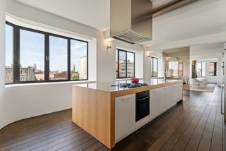 Located in an absolute prime location at Tunnelplaats, in the heart of Eilandje, you are within walking distance of MAS, the marina, Release Gym, Felix Pakhuis, and numerous leading restaurants and hotspots. Here, you can enjoy the bustling city life while coming home to an oasis of space and tranquility.<br /><br />This impressive 326 sqm loft, situated on the fifth floor of an iconic Art Deco building from 1937 (designed by Apollon Lagache), offers an exceptionally open living feeling. Thanks to the generous facade width and large windows, the living space is bathed in natural light, providing a panoramic view of the Antwerp skyline. From your living room, you can see iconic landmarks such as the Boerentoren, the Cathedral of Our Lady, MAS, and the many characteristic towers that give the city its unique silhouette.<br /><br />The solid parquet floor, stylish built-in gas fireplace, and fully equipped open kitchen with kitchen island create a warm, luxurious atmosphere. The adjoining circular space is the perfect place for an exclusive home office, reading corner, or lounge with spectacular city views. Currently, the loft has two very spacious bedrooms, including a master suite with custom dressing room and ensuite bathroom. Thanks to the thoughtful floor plan, one or even two additional bedrooms can easily be created, allowing for a layout with up to four bedrooms. There is also a second shower room.<br /><br />An additional asset is the communal rooftop terrace of approximately 200 sqm with breathtaking 360° panorama of Antwerp. There are already concrete renovation plans for this rooftop, transforming it into a green rooftop with solar panels. The preparatory documentation for this is already available.<br /><br />The loft also has a favorable EPC label C (215 kWh/m²), compliant electricity, is asbestos-free, and equipped with air conditioning, an alarm system, and a reinforced security door. A spacious private cellar storage is included. An indoor parking space with the option for a charging point can be purchased optionally (€35,000).