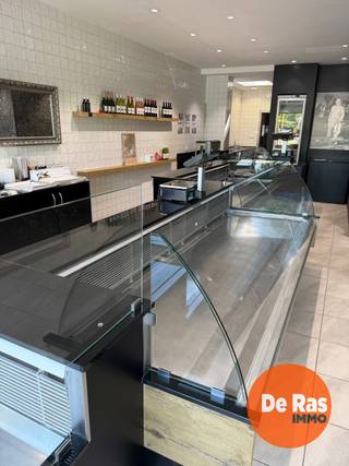 AALST - Handelspand met woonst op toplocatie<br /><br />Deze veelzijdige handelszaak met ruime woonst en uitgebreide opslagmogelijkheden is uitstekend gelegen vlak aan de Houtmarkt, in het centrum van Aalst. Dankzij de centrale ligging geniet het pand van een uitstekende bereikbaarheid en een sterke commerciële zichtbaarheid.<br /><br />Het handels gelijkvloers bevindt zich in een perfecte staat en omvat een moderne, recent ingerichte winkelruimte met een ruime toonbank, aangevuld met verschillende praktische werkruimtes, koelruimtes, bureauruimte en sanitair. Achteraan het perceel bevindt zich een ruime magazijn-/garageruimte met aansluitend een grote buitenparking, wat zorgt voor een optimale logistieke meerwaarde.<br /><br />De bovenliggende woonst biedt een aangename combinatie van comfort en ruimte en bestaat uit drie slaapkamers, een badkamer, een open keuken, een ruime leefruimte, een terras, kelder en een nog verder in te richten zolderverdieping met mezzanine.<br /><br />Met een totale oppervlakte van maar liefst ca. 400 m² biedt dit pand een uitzonderlijk potentieel voor ondernemers, zelfstandigen of investeerders. De combinatie van commerciële ruimte, opslagmogelijkheden en een ruime woning maakt dit een uniek aanbod met tal van gebruiksmogelijkheden in het hart van Aalst.<br /><br />Voor meer informatie of een bezoek, kan u ons steeds contacteren: 053/60.65.60.