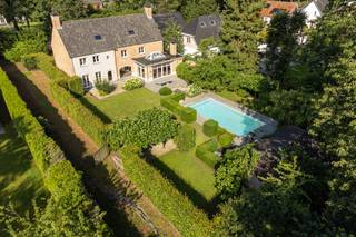Bijzondere ruime villa (bew. opp. 487m² + poolhouse) met 5 tot 7 slaapkamers, 3 badkamers, dubbele inpandige garage, zwembad, poolhouse enz. Deze villa is gelegen is gunstig gelegen op een mooi aangelegd perceel van 2665m² in een groene omgeving op de grens met Halle en Schilde en in directe nabijheid van in-en uitvalswegen, winkels, scholen enz.<br /><br />INDELING: Via automatische toegangspoort betreden we het perceel met voldoende parkeergelegenheid, dubbele carport enz. - Royale inkomhal met gastentoilet - Zeer ruime leefruimte met mooie lichtinval d.m.v. het vele raamwerk - Vervolgens grote keuken met aanpalend aangebouwde veranda (2013) - Verder is er een aparte eetkamer/polyvalente ruimte en een dubbele garage alsook wasplaats - V1: Grote nachthal met toegang tot 5 slaapkamers en 3 badkamers waarvan 1 masterbedroom met aanpalend dressing en badkamer. V2 omvat een grote zolderruimte en ruimte voor technieken (mogelijk 2 slpk's extra). Tuin: Geheel aangelegd en mooie vormgeving d.m.v. de perceelsbreedte van ca. 30m en voorzien van zowel zwembad als poolhouse (2005). Verder is er nog een grote dubbele carport vooraan de woning voorzien en is er een grote kelder.<br /><br />BIJZONDERHEDEN: Zeer ruime en tijdloze woonst - Ideaal voor grote gezinnen, wonen/werken enz. - Cv gas vloerverwarming + radiatoren - EPC: 204 UC: 3893860 - Destijds kwalitatieve materiaalkeuze doch opfrissing nodig - Pscore: B: Gscore: A - Stedenbouwkundige informatie in aanvraag.