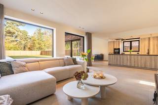 <strong><strong>Hoogwaardig afgewerkte, zeer recente villa in tijdloze pastorijstijl met o.a. 3 à 4 slaapkamers, 2 badkamers, bureauruimte, grote zolderverdieping en bijkomend afzonderlijke atelier- hobby- of garagegruimte achteraan. Het geheel ligt op een perceel van ca. 868m², uitstekend gelegen - centraal, doch rustig - nabij de Wezelse bossen vlakbij het centrum van Mol en Lommel. De woning van bouwjaar 2024 is uiterst energiezuinig (geothermische warmtepomp, zonnepanelen, ventilatie type D, etc.) en werd doorgedreven kwalitatief afgewerkt en ingericht voor eigen bewoning. De woning is overal voorzien van vloerverwarming en vloerkoeling (incl. bovenslaapkamers, excl. zolder). Nabij natuur- en recreatiegebied De Keiheuvel en De Most, scholen, dorpskern Wezel, stadskern Mol en bovendien op wandel- en/of fietafstand van alle voorzieningen (Alma, Spar, etc.) en sportfaciliteiten (padel, tennis, voetbal). EPC-score van 12kWh/m²/jaar (energielabel A). De woning is gelegen nabij Lommel, Postel, Mol en Nederland.<br /><br /></strong></strong><span>Gelijkvloerse verdieping - niveau 0:<br /></span><em><br /></em>Via de inkomhal met gastentoilet en vestiairegedeelte (inbouwkasten), heeft u toegang tot de afzonderlijke bureauruimte (werk- of studieruimte) en de woonkamer. De riante en lichtrijke woonkamer is verdeeld in een zitgedeelte (links), een open leefkeuken (rechts vooraan) en eetkamerdeel (rechts achteraan). De leefruimte op meerlagige kwaliteitstegel is voorzien van vloerverwarming, inbouwspots en wandverlichting. Vanuit deze leefruimte heeft u toegang tot open de keuken met verder toegang tot de bijkeuken / wasplaats. De keuken zelf is luxueus afgewerkt en geïnstalleerd met volgende kwaliteitstoestellen (allen AEG): inductiekookplaat, vaatwas, combi-(microgolf)oven en combi-stoomoven, legio kastruimte en een ruime ijskast. Er is ook een Quooker voorzien (ingebouwd aan/onder de watersteen in het kookeiland).<br /><br />Aan de keuken bevindt zich een open eetkamerlounge met hoge raampartijen en schuifraam met toegang tot het buitenterras.<br /><br />De keuken geeft tot slot toegang tot de wasplaats. Deze ruimte is eveneens volledig voorzien van inbouwkastruimte. Verder bevinden zich in deze ruimte ook alle sanitair-technische installaties (o.a. warmtepompsysteem) en is er plaats voor een extra diepvriezer of berging. <br /><br /><span>Eerste verdieping - niveau 1</span>:<br /><em><br /></em>De vaste trap in de inkomhal leidt tot de eerste verdieping. Hier bevinden zich 3 ruime slaapkamers en 2 uitgeruste badkamers (waarvan 1 met ligbad en inloopdouche en 1 met inloopdouche). De hoofdslaapkamer beschikt over een eigen dressing. 1 slaapkamer doet thans dienst als fitnessruimte.<br /><br /><span>Tweede verdieping - niveau 2</span>:<br /><em><br /></em>De tweede verdieping is eveneens te bereiken via een vaste trap en is nog onafgewerkt. Deze ruimte kan eenvoudig omgevormd worden tot ruime 4e slaapkamer, thuisbioscoop of hobbyruimte.<br /><br /><span>Buitengebeuren</span>:<br /><em><br /></em>De woning heeft een oprit aan de zijkant van de woning (elektriciteitsleidingen voor poortafsluiting zijn aanwezig), er is een garage in het bijgebouw achteraan die evengoed dienst kan doen als extra werkplaats of tuinhuis. Er is verder legio parkeerruimte en de tuin is ruim en onderhoudsvriendelijk aangelegd.<br /><br /><span>Bijzonderheden</span>:<br />- Recente woning (2024), uiterst energiezuinig<br />- EPC van 12 kWh/m²/jaar (label A)<br />- Zonnepanelen en warmtepomp <br />- Vloerverwarming en -koeling (niveau 0 en 1)<br />- Bewoonbare opp.: ca. 300m²<br />- Riante zolder: ca. 60m²<br />- 2 badkamers en 2 afzonderlijke toiletten<br />- Uiterst gunstige ligging op wandelafstand van centrum Wezel<br />- Op wandelafstand van bos en natuurgebied; achterliggend bos