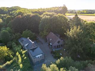 Welkom in het pittoreske Cotthem in Sint-Lievens-Houtem, een bijzondere, bosrijke omgeving met natuurgebied, akkers en weilanden. Midden in dit groene decor bevindt zich De Boomgaard, een veelzijdig domein van maar liefst 5.020 m² waar toerisme, horeca, verblijf en wonen samenkomen. De omgeving is bijzonder geliefd bij wandelaars, fietsers en ruiters en vormt dan ook een prachtige uitvalsbasis voor het ontdekken van de Vlaamse Ardennen.<br /><br />Het domein bestaat uit twee vrijstaande gebouwen. Het eerste gebouw telt circa 473 m² bruikbare vloeroppervlakte, werd rond 2012 grondig gerenoveerd en beschikt over EPC-label B. Hier bevinden zich zeven gastenkamers, elk met een eigen badkamer en een verschillende indeling. De blikvanger is de penthousesuite met een eigen dakterras, jacuzzi en prachtig uitzicht over de groene omgeving. In hetzelfde gebouw bevindt zich een private woongelegenheid, waardoor wonen en uitbaten perfect gecombineerd kunnen worden. Een technisch-/waslokaal, dubbele garage en kelder vervolledigen het geheel.<br /><br />Het tweede gebouw omvat circa 328 m² bruikbare vloeroppervlakte en vormt het horecagedeelte van De Boomgaard. Op het gelijkvloers bevinden zich een gezellige taverne/restaurant met professionele keuken, bistro en ontbijtzaal. De verdieping biedt een ruime polyvalente ruimte, momenteel ingericht als twee gastenkamers of één groot gastenverblijf voor groepen, met kitchenette en twee badkamers. Ook hier is een kelder aanwezig. Dit gebouw beschikt over EPC-label D.<br /><br />Ook buiten heeft deze eigendom bijzonder veel te bieden. Rond het restaurant liggen verschillende terrassen en de grote tuin met hoogstambomen creëert een ware oase van rust. In de tuin bevindt zich bovendien een bijgebouw dat tijdens de zomerperiode perfect dienst kan doen als zomerbar of ‘place de l’apéro’. Alles is hiervoor reeds aanwezig. Daarnaast is er een bunker die gebruikt kan worden als koele opslagplaats voor dranken.<br /><br />Met een ruime parking voor circa 15 wagens is er ook voldoende parkeergelegenheid voor gasten en bezoekers. Alle constructies werden recent stedenbouwkundig vergund. In het verleden beschikte de site bovendien over een vergunning van Toerisme Vlaanderen voor 32 bedden, wat het toeristische potentieel van deze locatie extra onderstreept.<br /><br />Naast een verdere uitbating als B&B en horecazaak bieden de gebouwen, mits eventuele verbouwingen en het verkrijgen van de vereiste vergunningen, ook mogelijkheden voor een combinatie van wonen en werken, kantoorfuncties of een andere passende invulling.<br /><br />Ondanks de uitzonderlijk groene ligging is De Boomgaard vlot bereikbaar. Via de E40 ter hoogte van Wetteren en Erpe-Mere zijn onder meer Gent en Brussel goed bereikbaar.<br /><br />De Boomgaard is geen klassiek vastgoedaanbod, maar een complete belevingssite met een bijzondere geschiedenis en tal van toekomstmogelijkheden. Een unieke kans voor een ondernemer die horeca, verblijfstoerisme en evenementen wil combineren op één van de mooiste groene locaties van Sint-Lievens-Houtem.<br /><br />Interesse in De Boomgaard? Neem contact op met Immo Francois voor meer informatie of een bezoek ter plaatse.<br /><br />