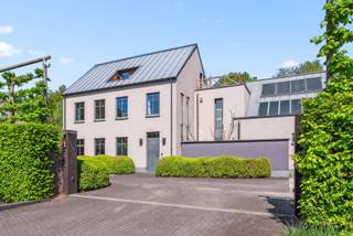 Deze uitzonderlijke villa is gelegen in een rustige, doodlopende straat met vrij uitzicht op groen, in de nabijheid van de golf van Keerbergen.<br /><br />Bij het betreden van de woning komt u in de inkomhal, voorzien van een gastentoilet en vestiaire(kamer). Vanuit de hal bereikt u de ruime en lichtrijke leefruimte met open haard en toegang tot een apart, overdekt terras dat afsluitbaar is en eveneens beschikt over een sfeervolle open haard. Aansluitend bevindt zich een bureauruimte, terwijl de leefruimte naadloos overgaat in de hyper-geïnstalleerde keuken, uitgerust met onder andere een gasfornuis, teppanyaki-plaat en wijnkoelkast.<br /><br />Verderop bevindt zich een polyvalente ruimte van maar liefst 72 m². Deze ruimte is een groot binnenzwembad dat opnieuw geactiveerd kan worden en vandaag ingericht is als een lounge ruimte en bureau. Daarnaast vindt u op het gelijkvloers ook een aparte badkamer met ligbad, dubbele lavabo en toilet.<br /><br />Op de eerste verdieping komt u via de ruime nachthal met ingemaakte kasten bij drie volwaardige slaapkamers, een master bedroom met eigen dressing en privéterras, en een badkamer met ligbad, inloopdouche, dubbele lavabo en toilet. Tevens is hier een aparte wasruimte voorzien.<br /><br />Via een vaste trap bereikt u de zolderverdieping, die volledig is ingericht en perfect dienst kan doen als extra slaapkamer, bureau of hobbyruimte. Aansluitend vindt u hier een royaal dakterras met een prachtig uitzicht op de aangelegde tuin.<br /><br />De villa is volledig onderkelderd en uitgerust met een domoticasysteem en geïntegreerd surroundsysteem. De tuin is mooi aangelegd en beschikt over een poolhouse met zwemvijver.<br /><br />Extra troeven:<br /><br />· Domoticasysteem<br /><br />· 2 laadpalen voor elektrische wagens<br /><br />· 5 airco-units<br /><br />· Poolhouse aan een vijver en extra tuinhuis <br /><br />· Alarmsysteem<br /><br />Voor een gedetailleerd overzicht van de indeling en nog veel meer, raden we je aan om onze website te bezoeken voor de grondplannen op www.imovastgoed.be. Voor verdere informatie en vragen, aarzel niet om contact op te nemen met Jean Heylen via jean.heylen@imovastgoed.be of bel naar 015/34.34.54.