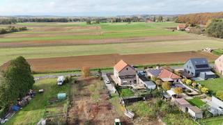 <p>Deze projectgrond in Tielt-Winge geniet een bijzonder sterke ligging voor de ontwikkeling van twee halfopen woningen. De percelen bevinden zich op slechts drie minuten rijden van de oprit van de E314 richting Leuven, terwijl ze tegelijk uitzonderlijk rustig liggen aan de rand van een natuurgebied.</p>
<p>Op het perceel staat momenteel een woning die, indien gewenst, kan worden afgebroken om de nieuwe ontwikkeling mogelijk te maken.</p>
<p>Er werd een verkavelingsvergunning afgeleverd voor twee kavels, elk met een perceelbreedte van 13,9 meter en een diepte van 50 meter. De voorziene bouwzones laten per woning een gevelbreedte van 10,8 meter en een bouwdiepte van 15 meter toe. Het achter- en zijliggend perceel worden samen met de bouwpercelen verkocht.</p>
<p>De bouwgronden liggen in woongebied met landelijk karakter; het aansluitende restperceel bevindt zich in agrarisch gebied. De gedetailleerde bouwvoorschriften zijn op aanvraag beschikbaar.</p>